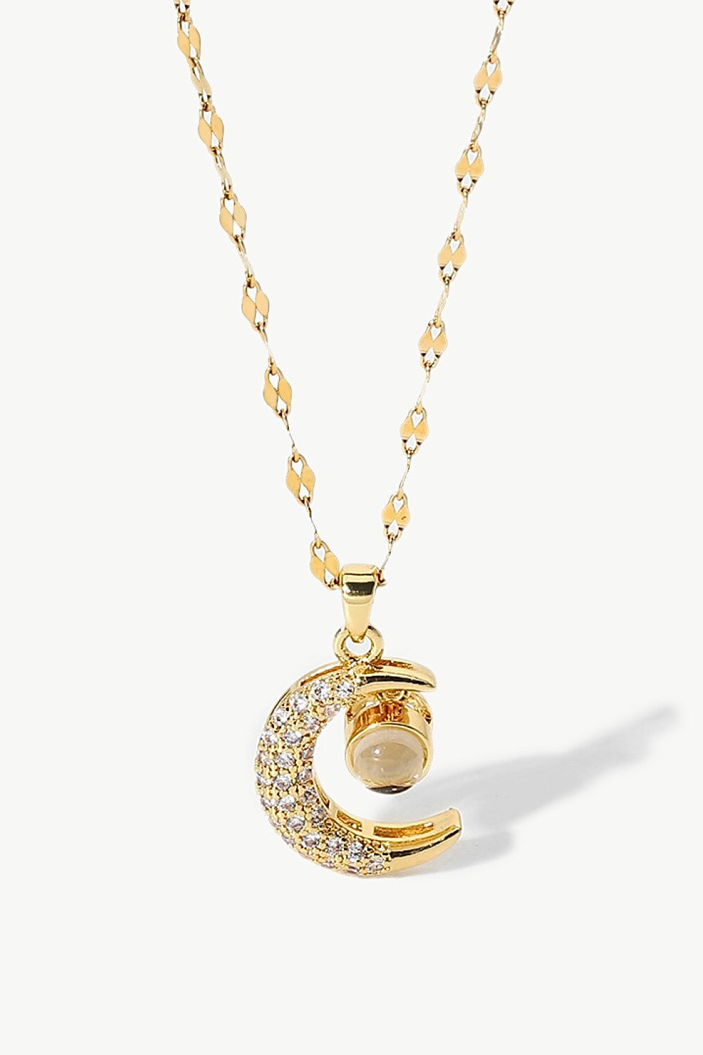 Inlaid Cubic Zirconia Moon Pendant Necklace featuring a delicate moon design and sparkling cubic zirconia, displayed in a flat lay studio setting.