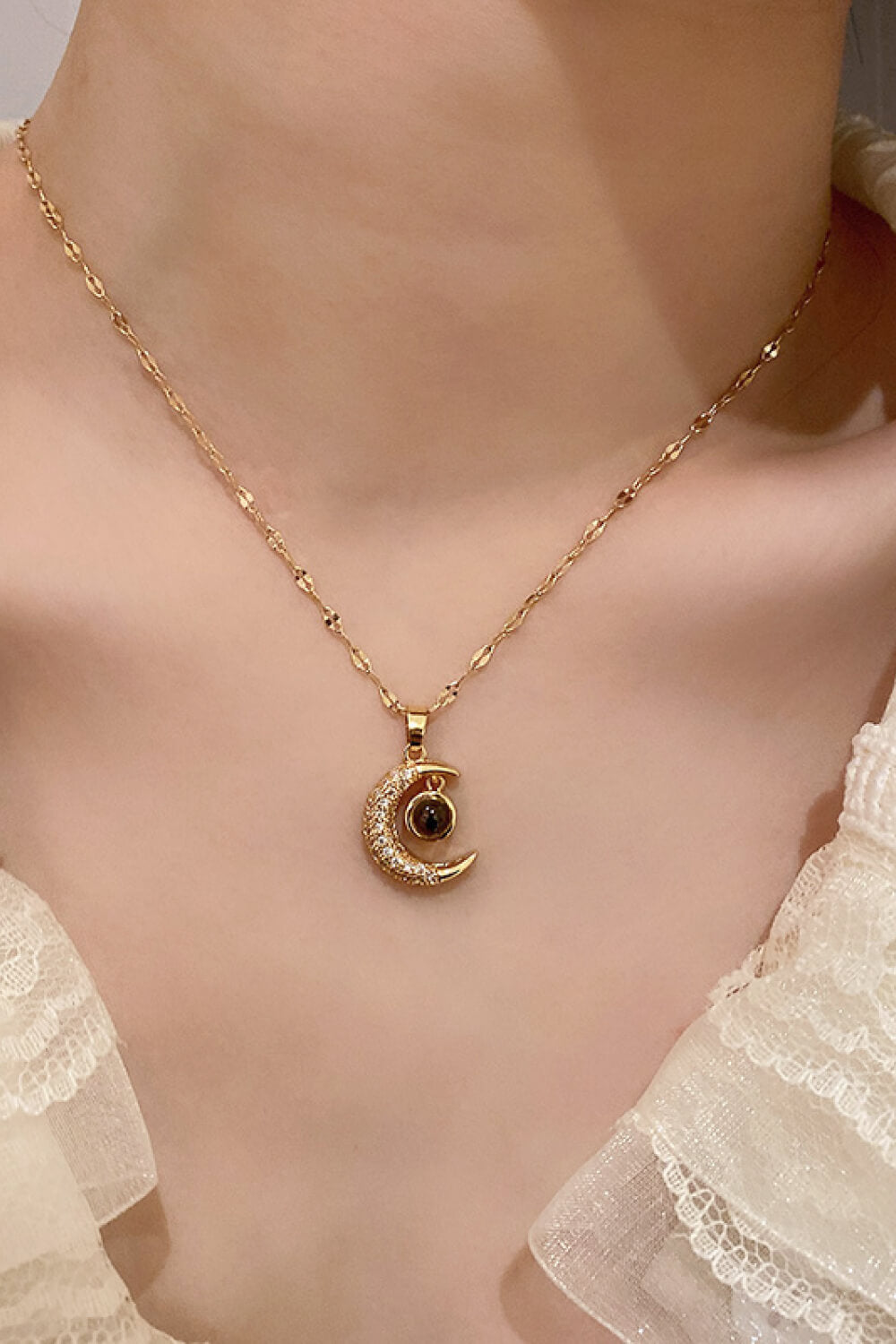 Inlaid Cubic Zirconia Moon Pendant Necklace featuring a delicate moon design and sparkling cubic zirconia, displayed in a flat lay studio setting.