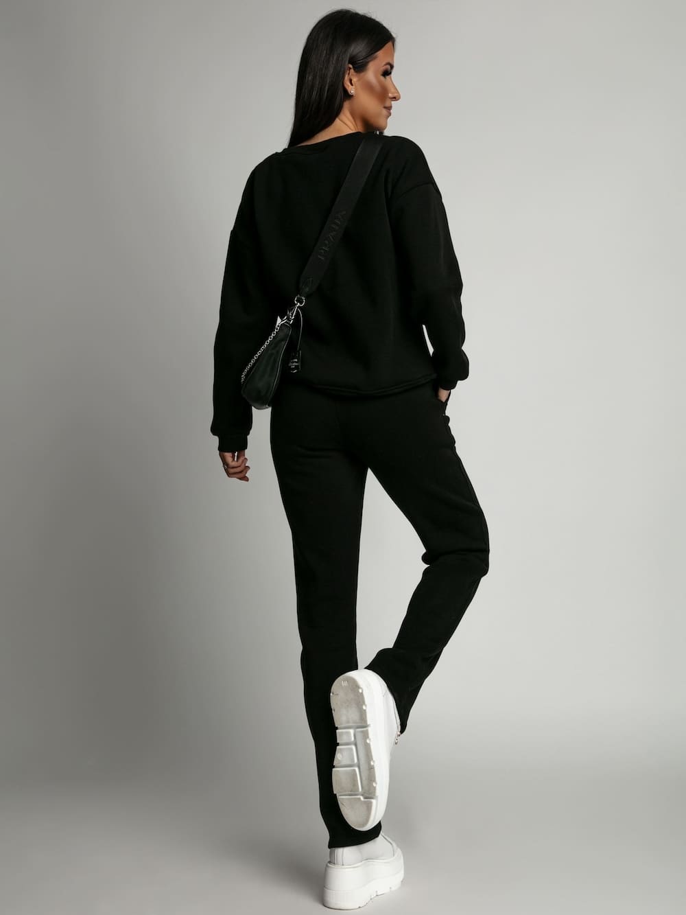 Women's insulated black tracksuit featuring a long-sleeved sweatshirt and loose pants, designed for comfort and style.