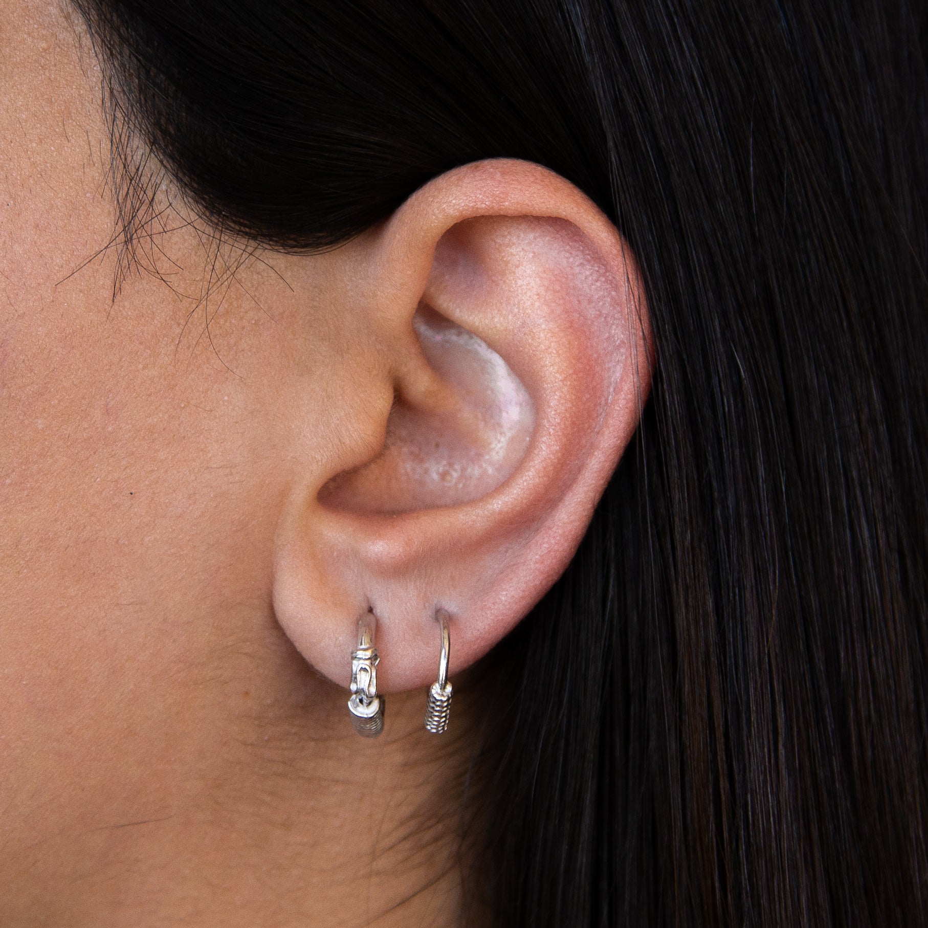 A pair of elegant Italian mini sterling silver hoop earrings, showcasing their shiny finish and delicate design.