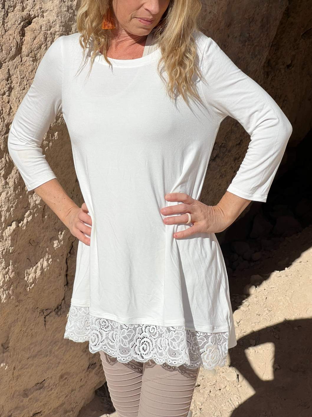 Ivory 3/4 sleeve tunic featuring a delicate lace hem, perfect for layering and stylish outfits.