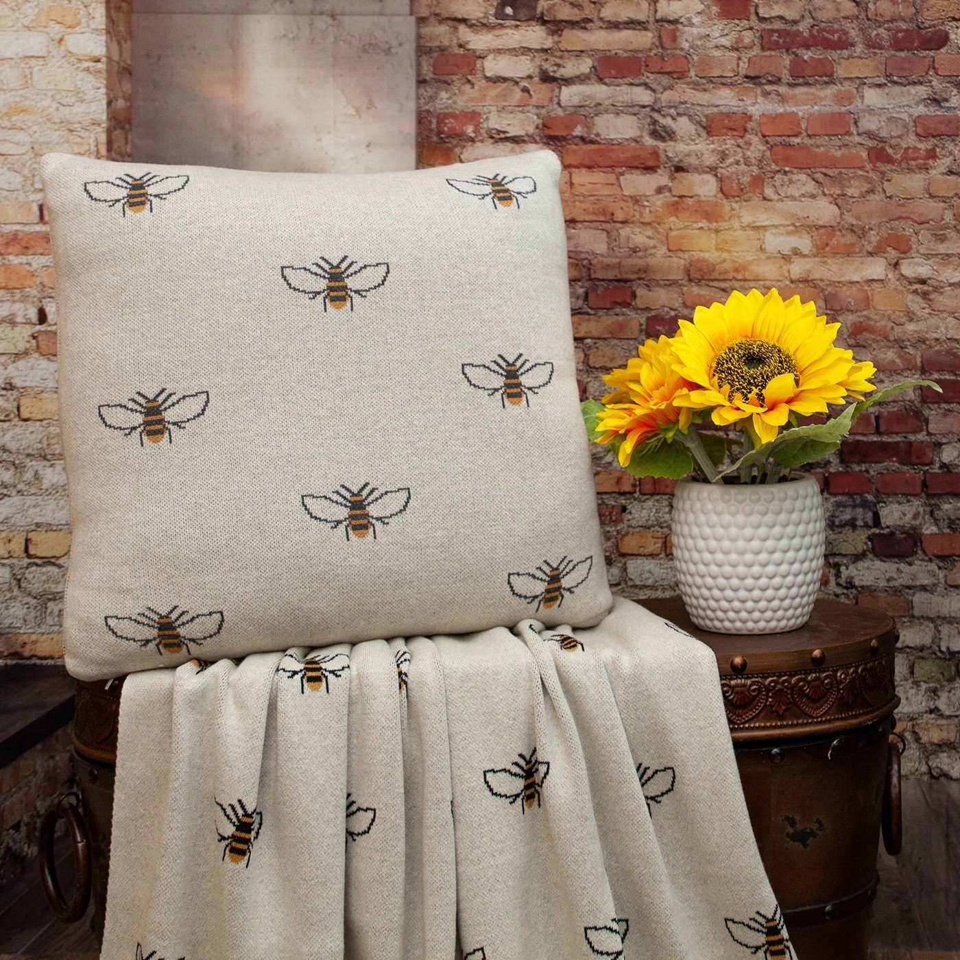 Ivory Bumble Bee Knitted Throw Blanket draped elegantly over a sofa, showcasing its unique bumble bee design and soft texture.