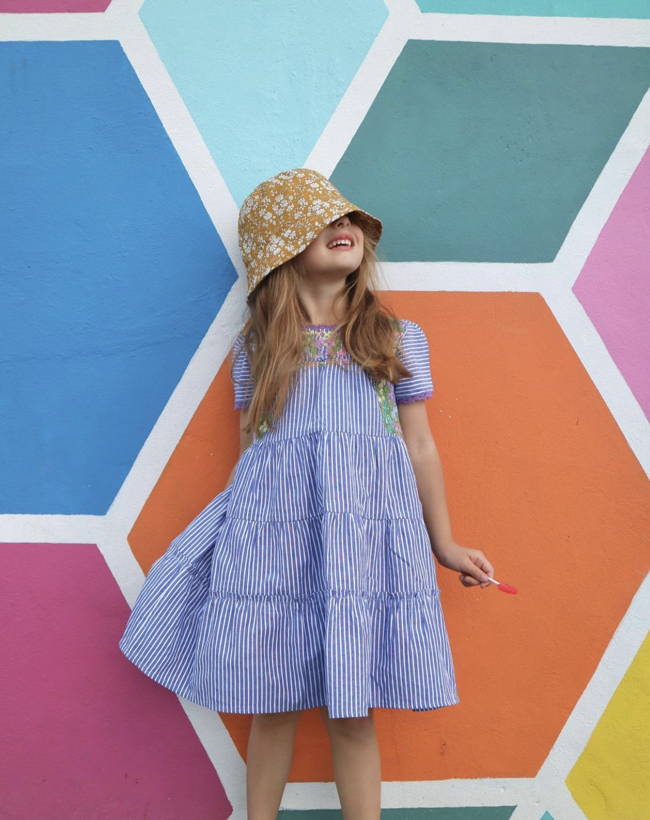 The James Dress featuring blue stripes, hand embroidery on the bodice, and short sleeves with crochet trim.