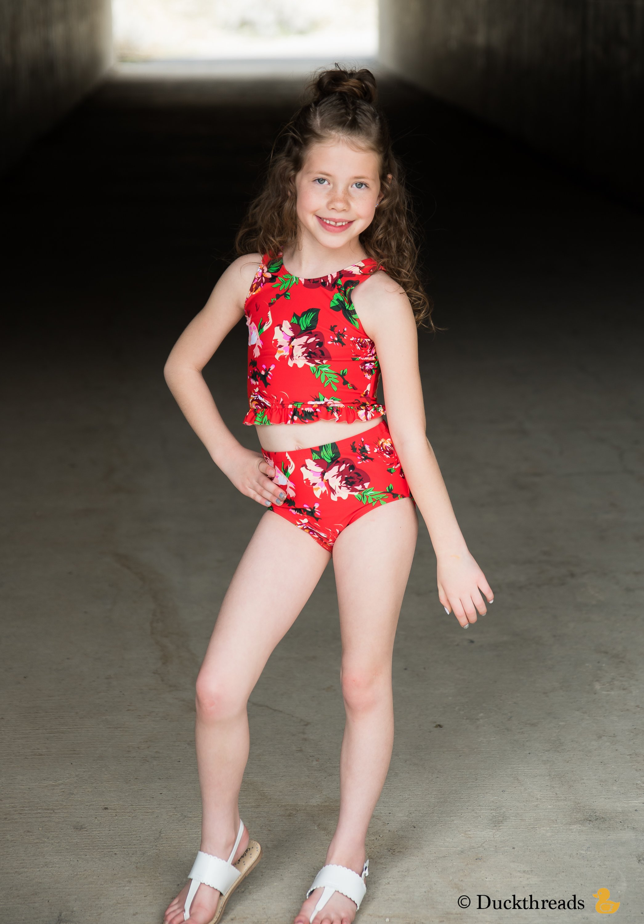 Janela Bay Red Floral Little Ruffle Swim Top featuring a vibrant floral print and playful ruffle detail along the bottom.