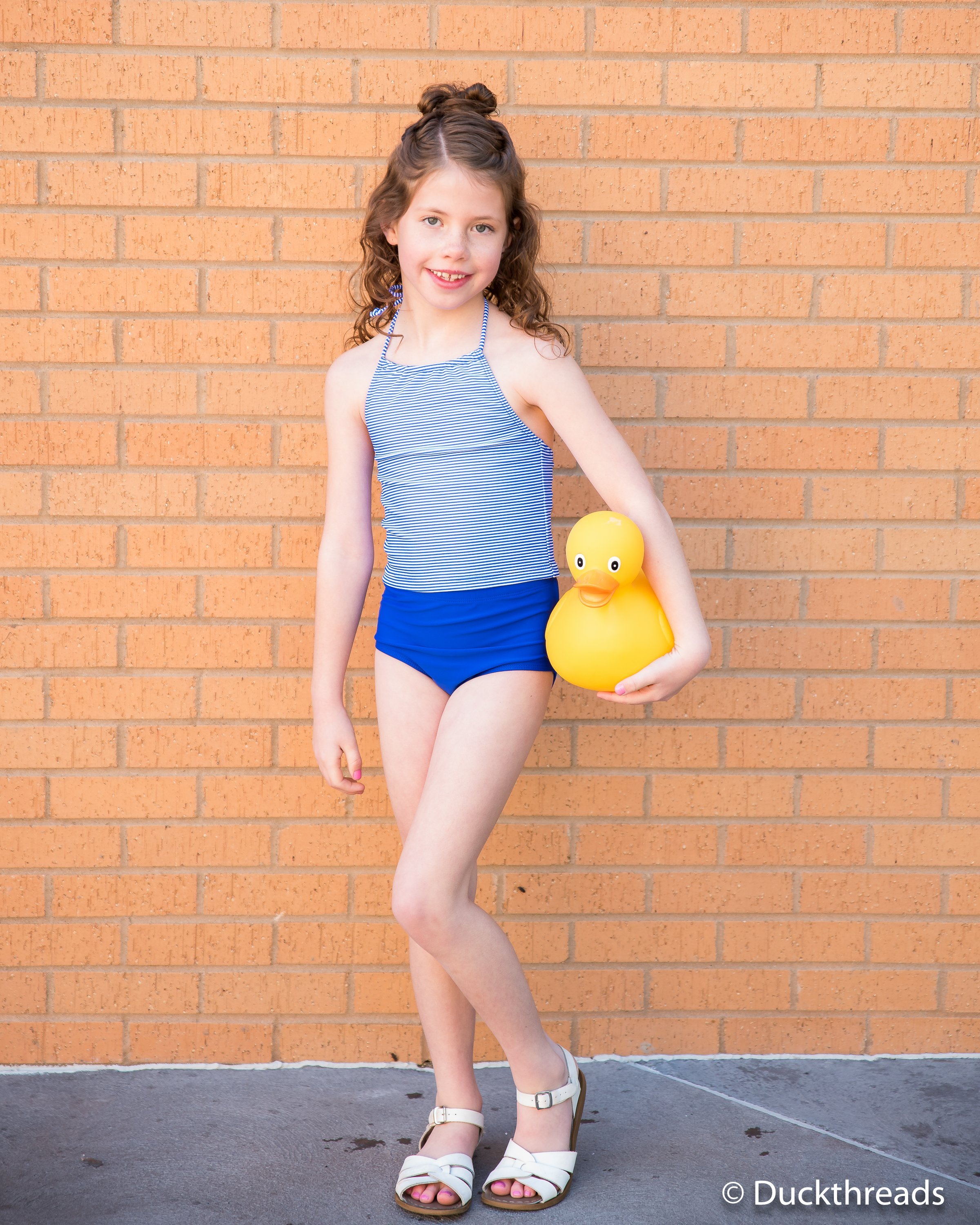 Janela Bay Royal Blue Stripe Swim Top featuring a halter neck design and mini blue striped fabric, perfect for summer beach outings.