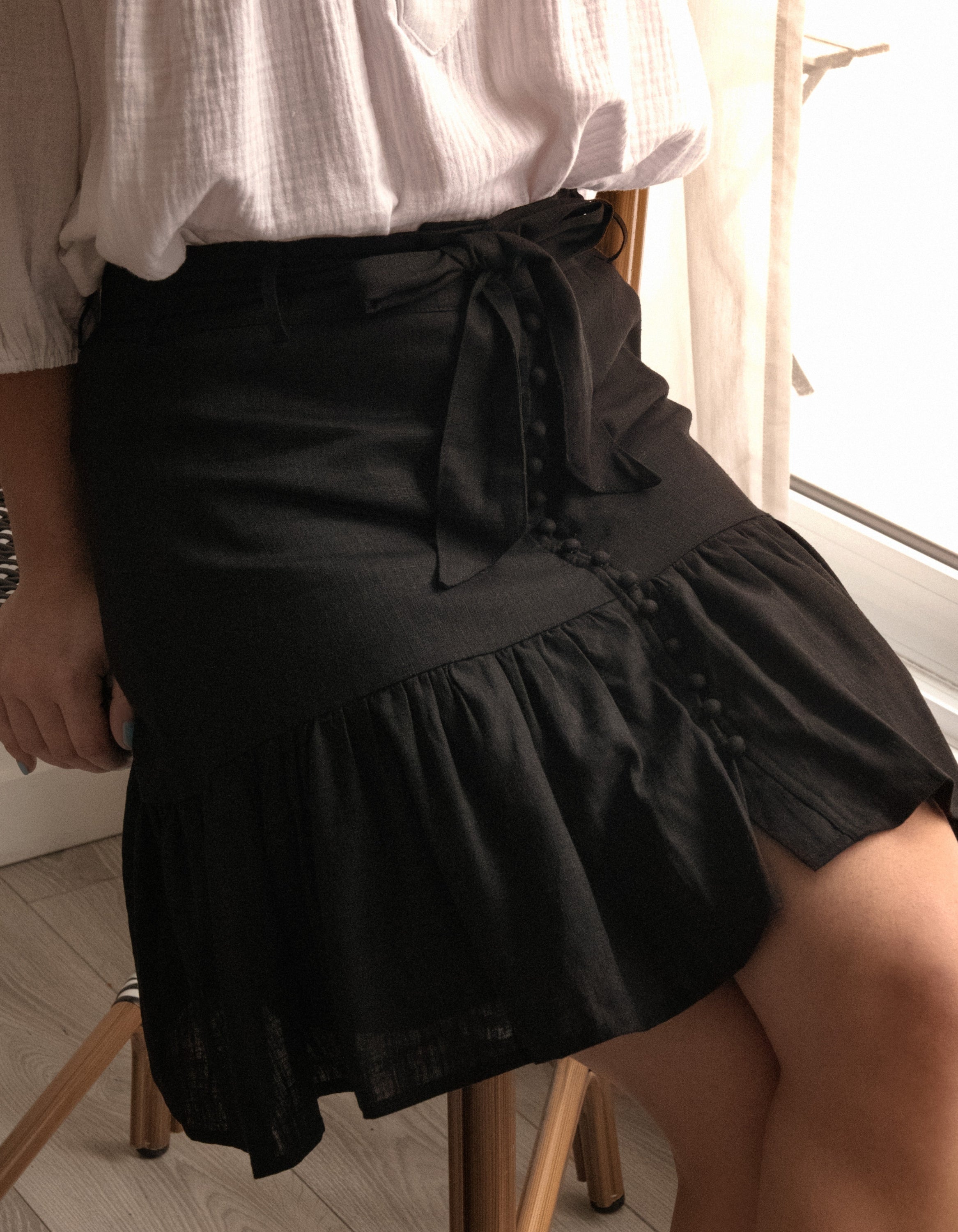 Jasmine Skirt in solid black, featuring a high-waisted design, removable self-belt, and vintage-inspired self-covered buttons.