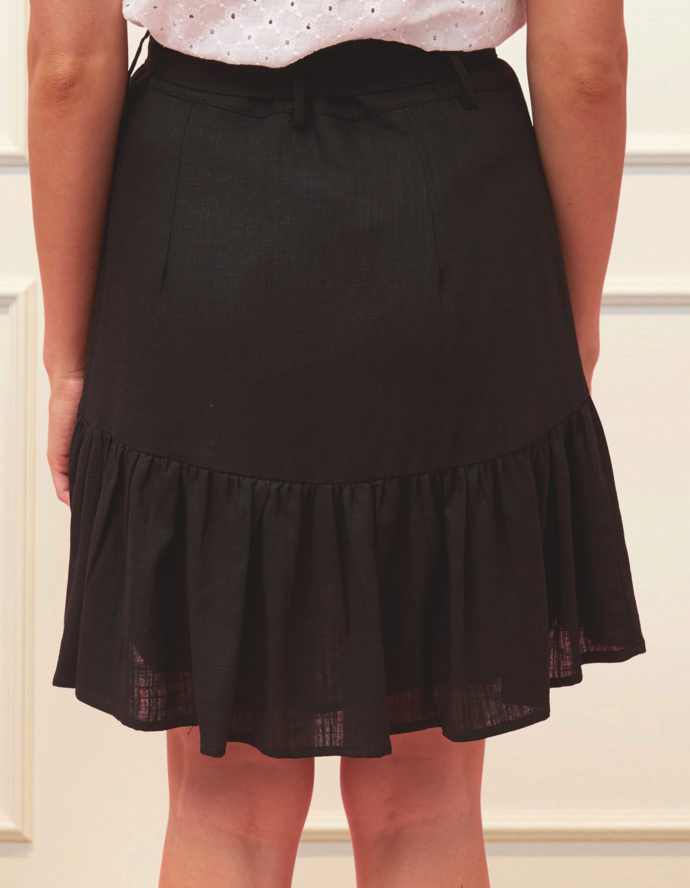 Jasmine Skirt in solid black, featuring a high-waisted design, removable self-belt, and vintage-inspired self-covered buttons.