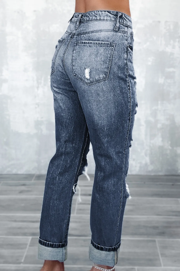 A pair of blue ripped jeans featuring a high waist, button and zipper closure, and side pockets, showcasing stylish ripped details.