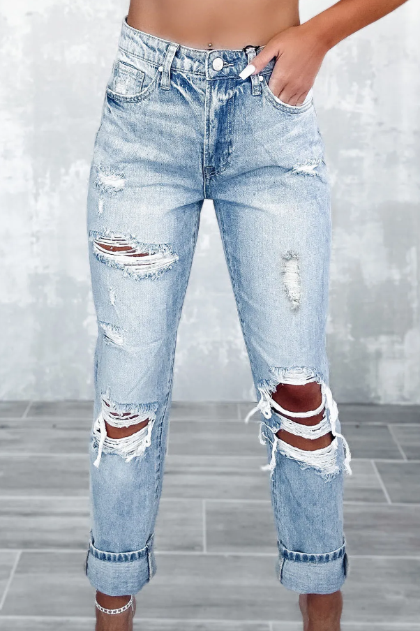 Light blue ripped jeans featuring a high waist, button and zipper closure, and side pockets, made from high-quality cotton.