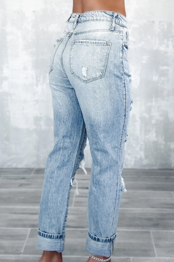 Light blue ripped jeans featuring a high waist, button and zipper closure, and side pockets, made from high-quality cotton.