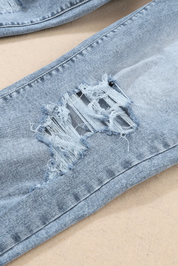 Light blue ripped jeans featuring a high waist, button and zipper closure, and side pockets, made from high-quality cotton.