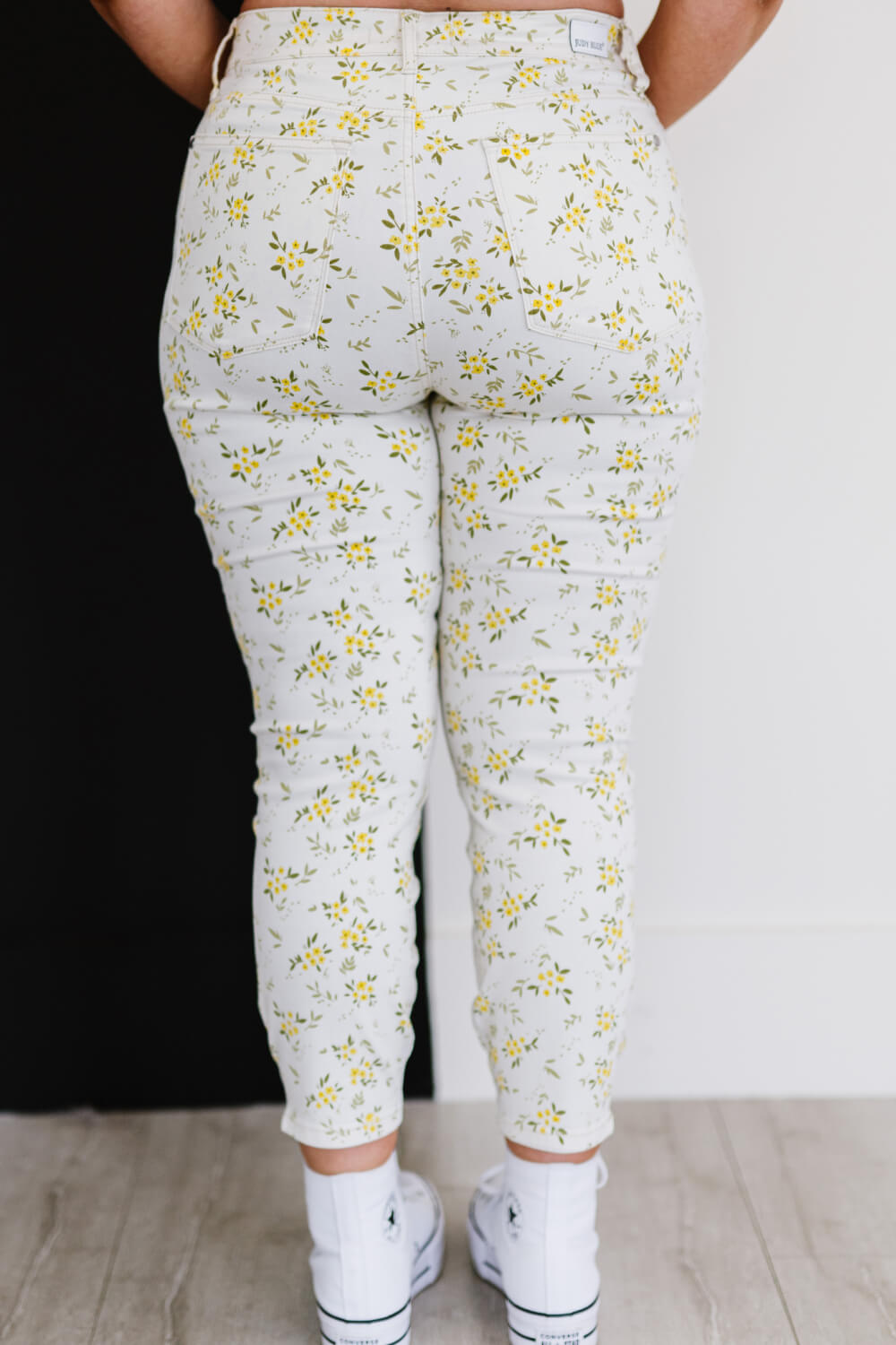 Judy Blue Golden Meadow Floral Skinny Jeans featuring a vibrant yellow floral pattern, mid-rise waist, and a slim fit design.