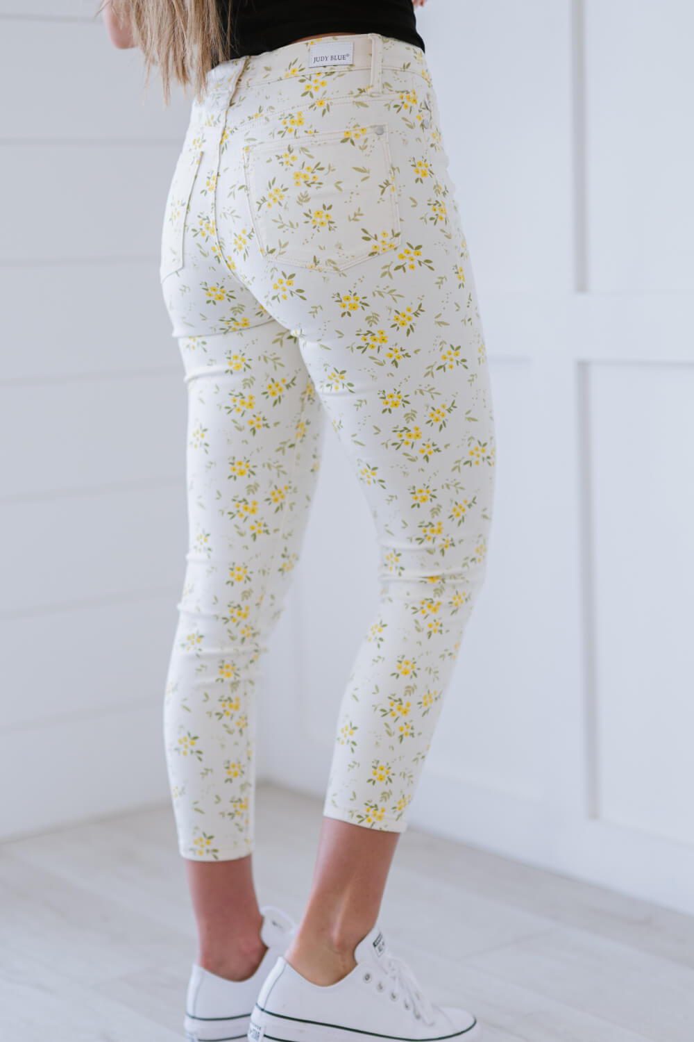 Judy Blue Golden Meadow Floral Skinny Jeans featuring a vibrant yellow floral pattern, mid-rise waist, and a slim fit design.