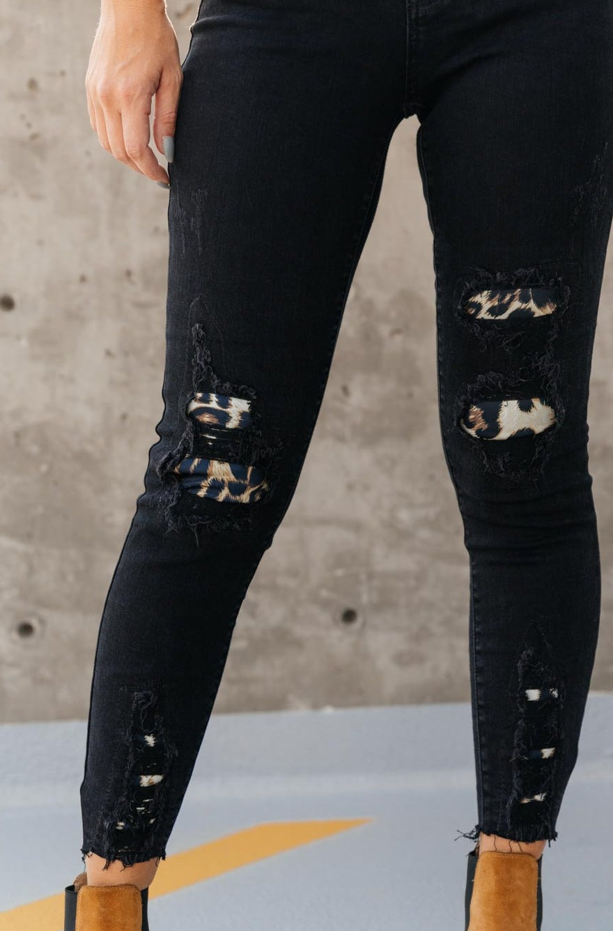 Judy Blue Into The Wild Distressed Skinny Jeans featuring black denim with animal print details and a raw hem.