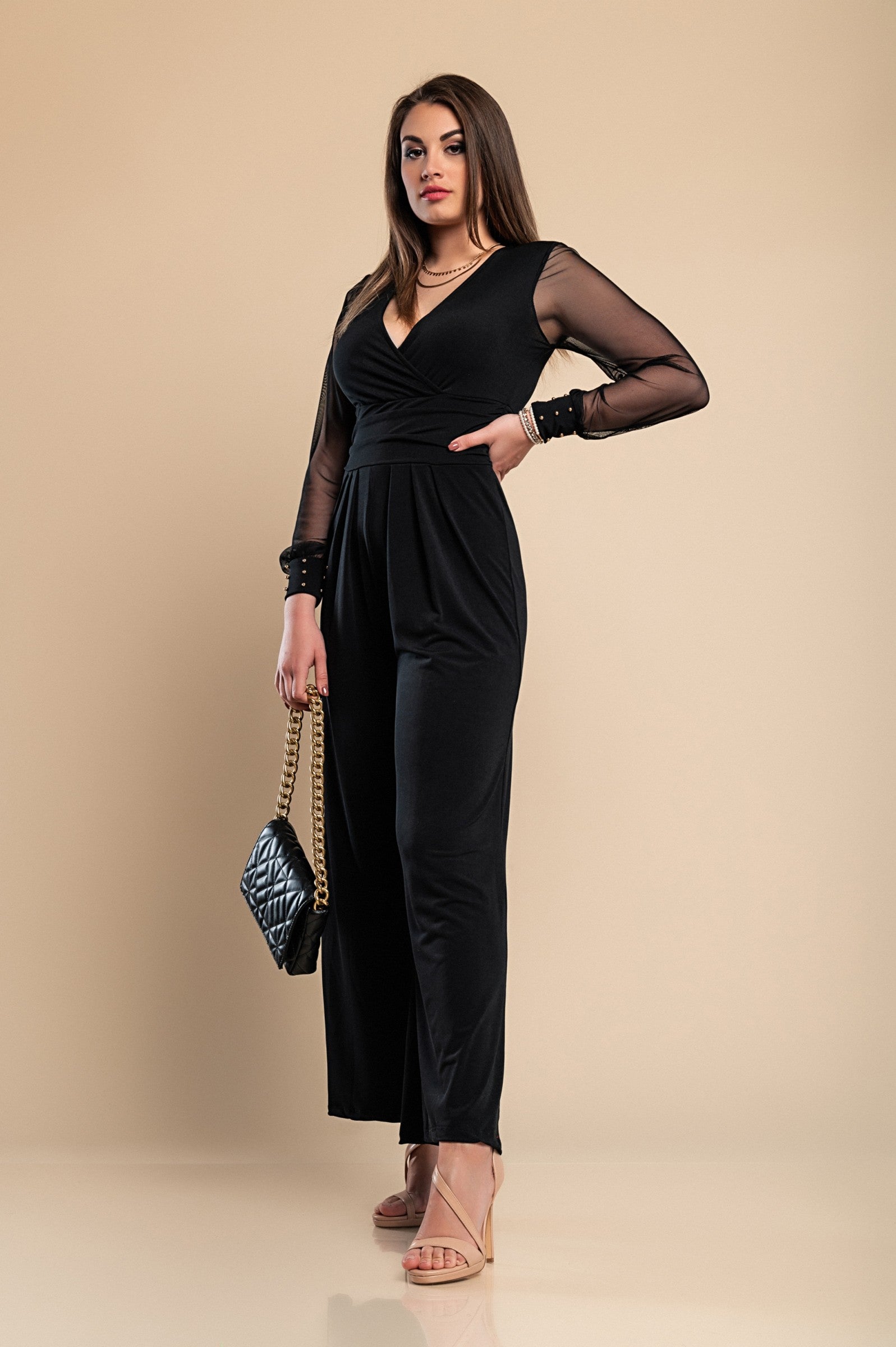 Elegant black jumpsuit with 'V' neckline and translucent long sleeves, featuring fashionable wrist accessories.