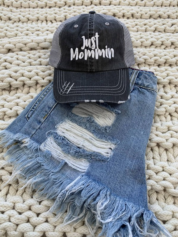 A stylish Just Mommin' embroidered hat featuring a trendy design, perfect for fashionable moms on the go.