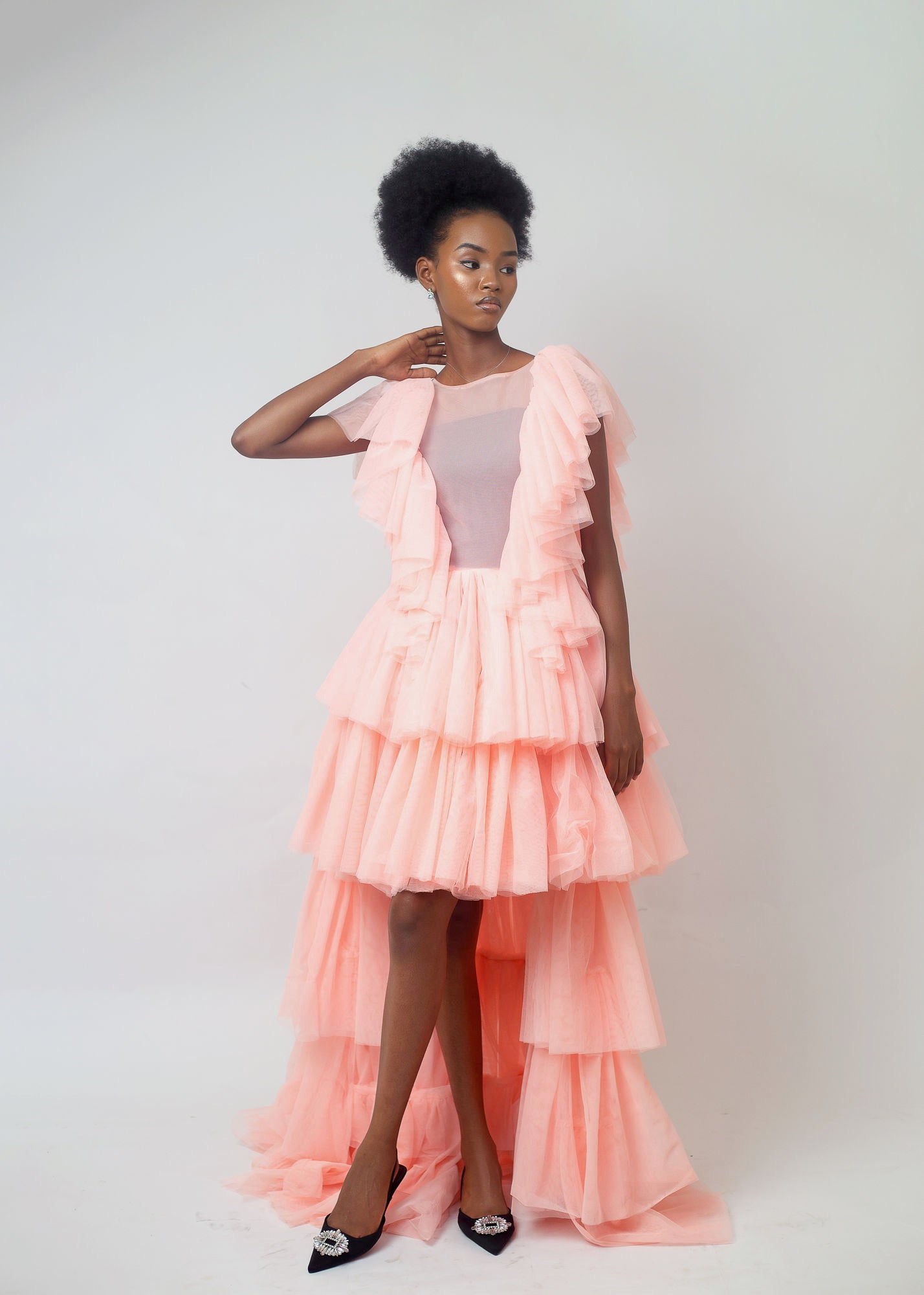 Kailani Dress in soft peach color featuring high-low hemline and layered ruffles, perfect for special occasions.