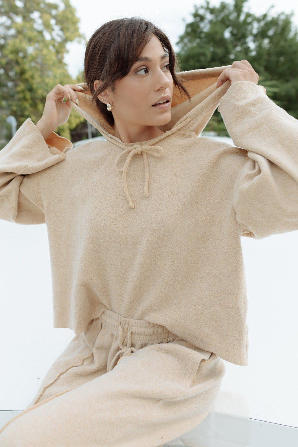 Kenny Hoodie in tan color featuring bell sleeves and a drawstring hood, made from organic cotton and recycled polyester.