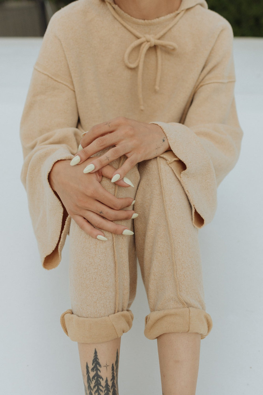 Kenny Pant in fleece tan color, featuring a drawstring waist, raw seam design, and pockets, styled with a matching top.