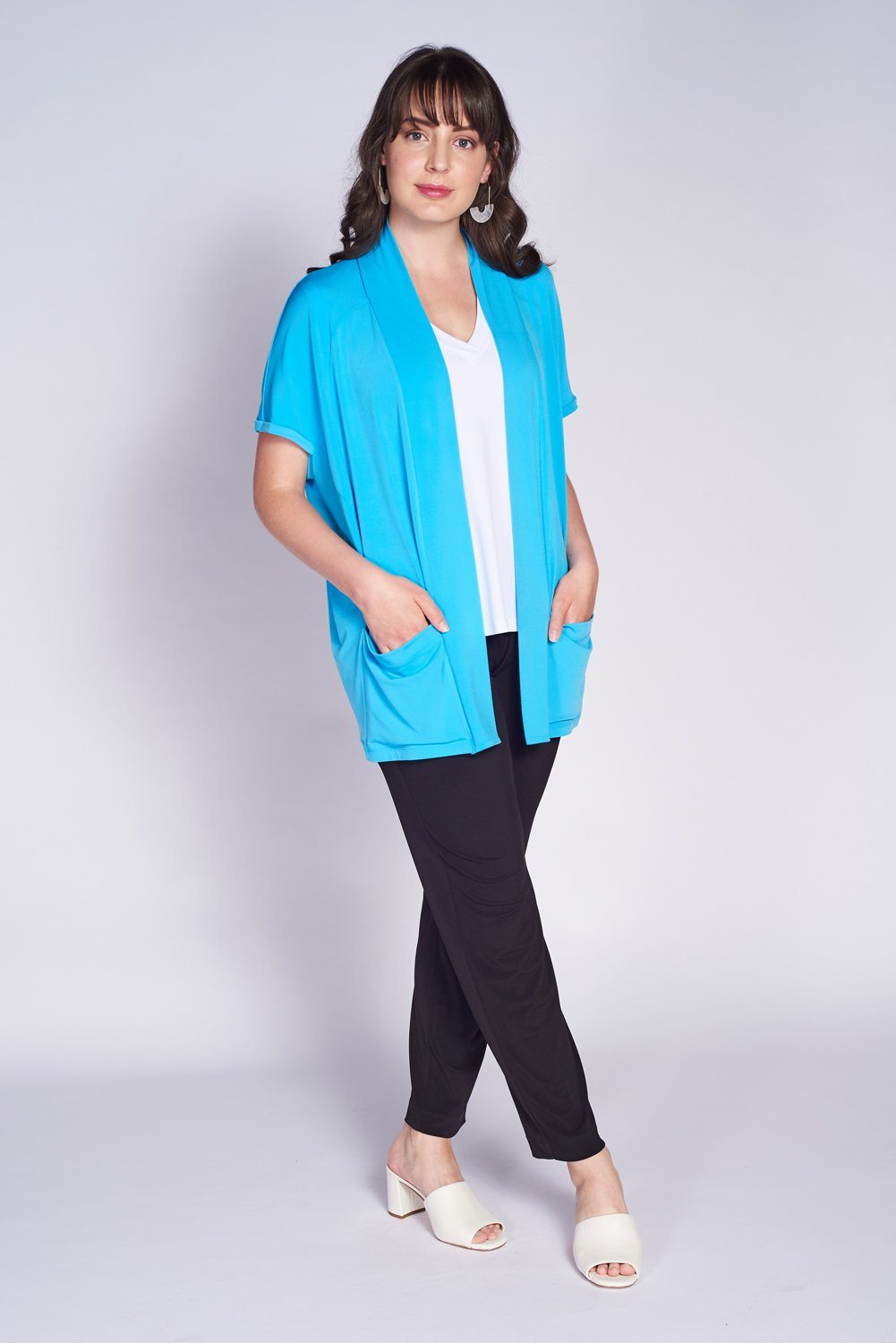 A stylish Key Hole Cardigan featuring a unique neck vent and pockets, showcasing its elegant design and high-quality fabric.