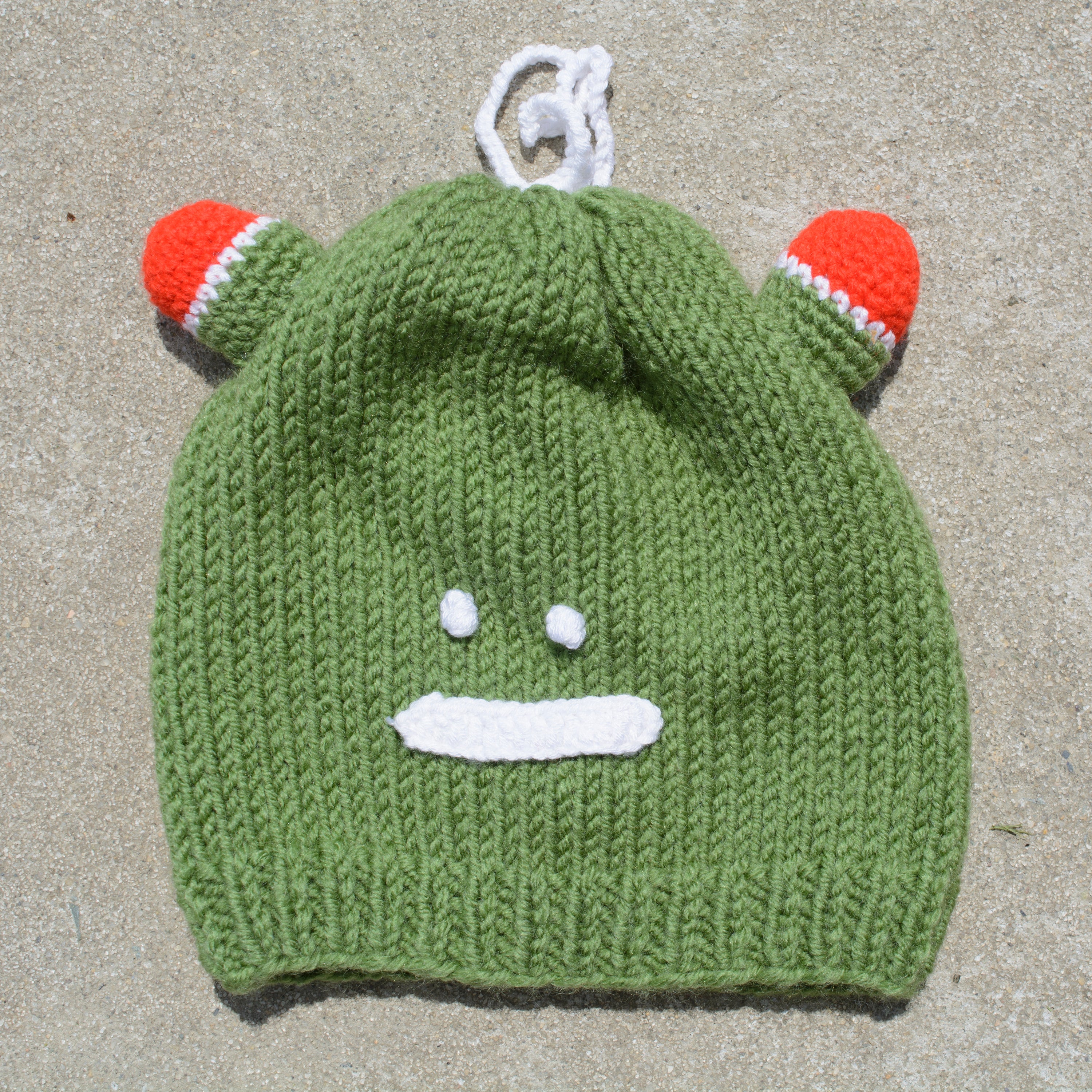 Hand-knitted frog wool beanie cap for kids, featuring a playful design and cozy fit, perfect for ages 2-7.