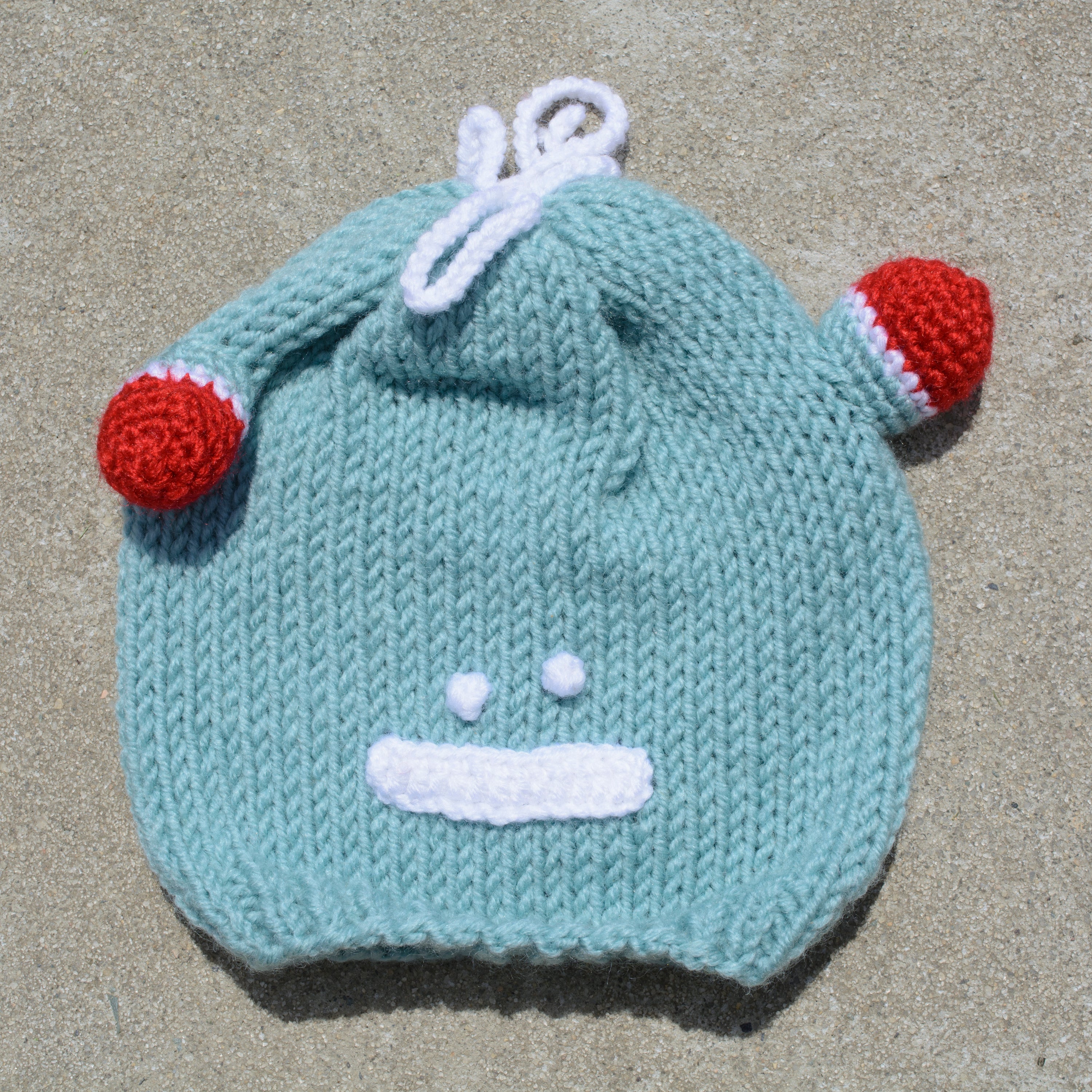 Hand-knitted frog wool beanie cap for kids, featuring a playful design and cozy fit, perfect for ages 2-7.