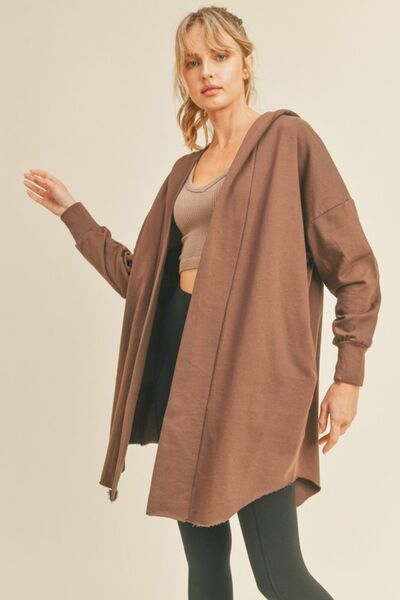 Kimberly C Open Front Longline Hooded Cardigan in a cozy setting, showcasing its longline design and attached hood.