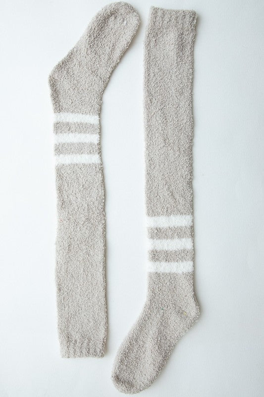 A pair of stylish knee-high boucle socks made from a soft polyester blend, featuring a textured design for added elegance.