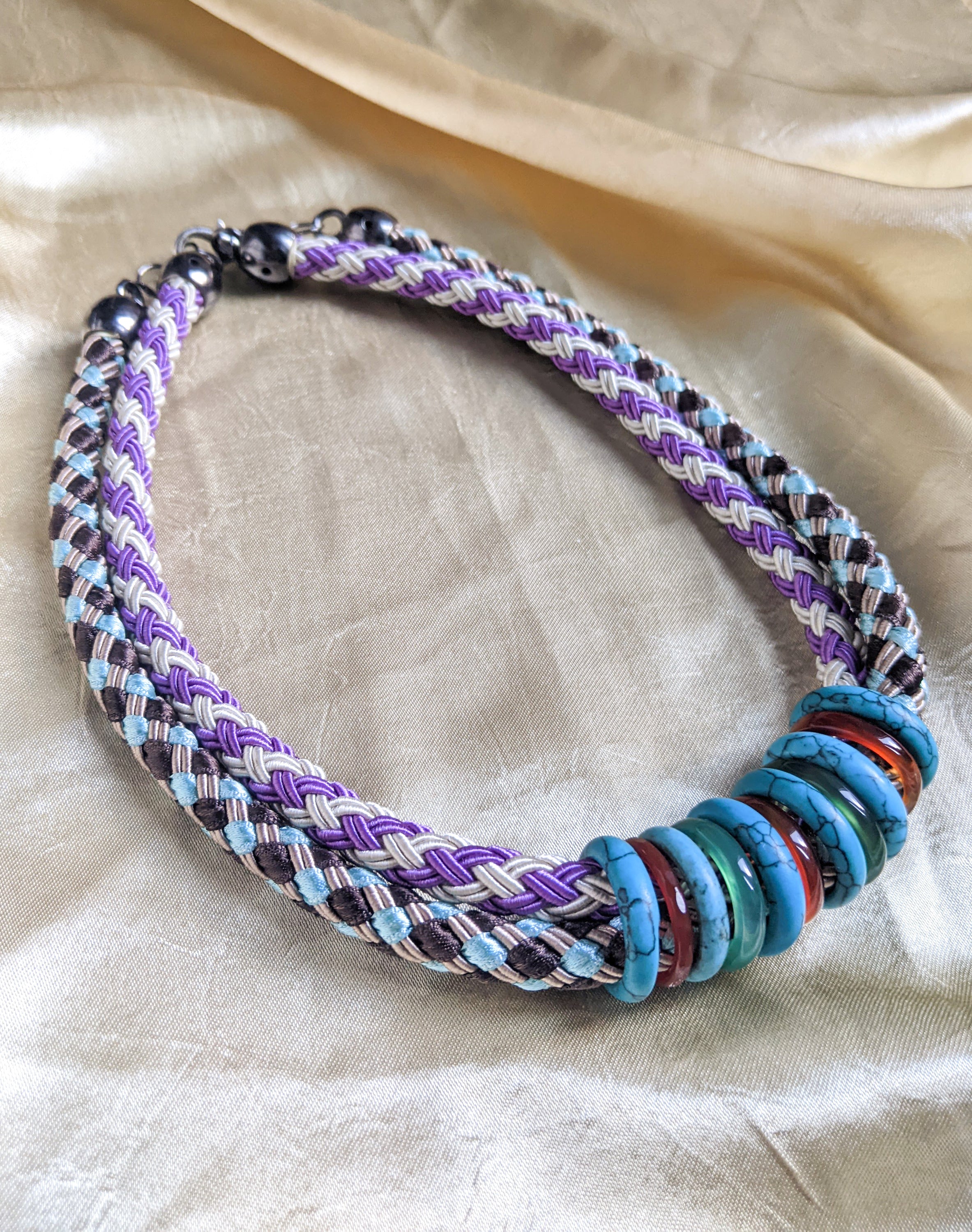 Knit rope choker featuring colorful rings in a double collar design, showcasing vibrant colors and a stylish look.