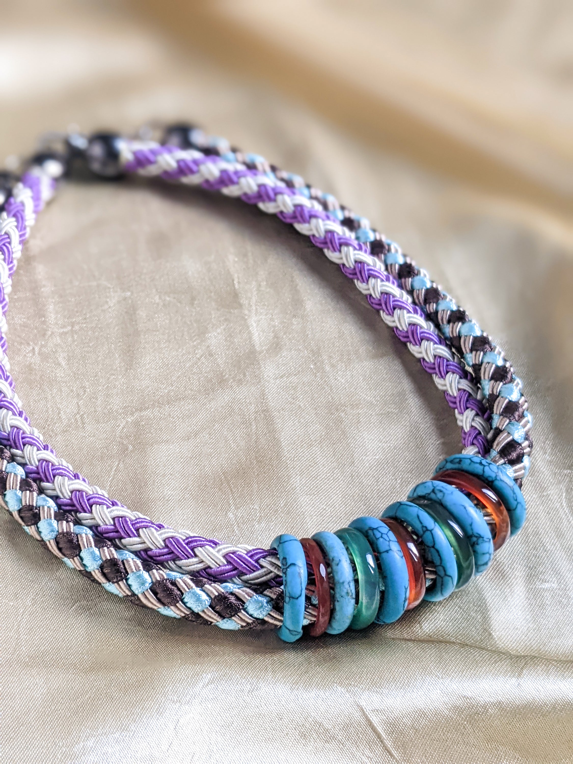 Knit rope choker featuring colorful rings in a double collar design, showcasing vibrant colors and a stylish look.