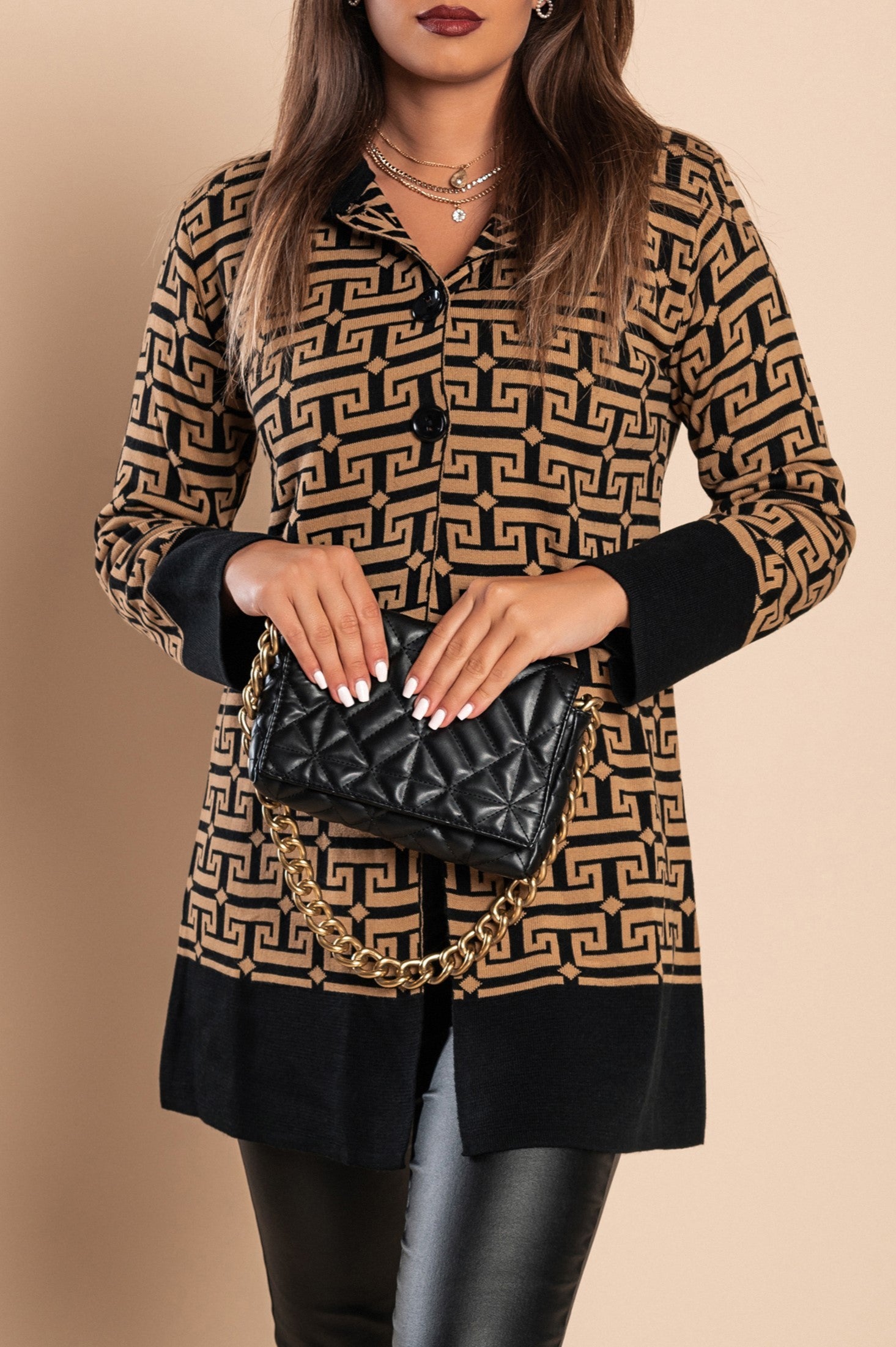 Elegant black knitted cardigan with geometric pattern, featuring long sleeves and high collar, made from wool and acrylic blend.