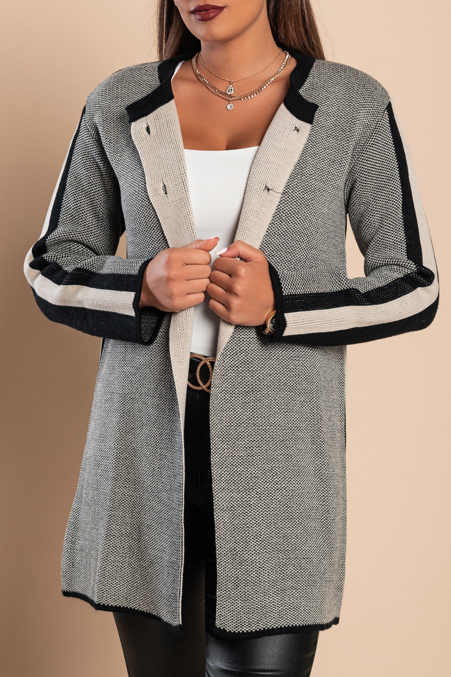 Elegant black knitted cardigan with buttons, showcasing long sleeves and a round neck design.