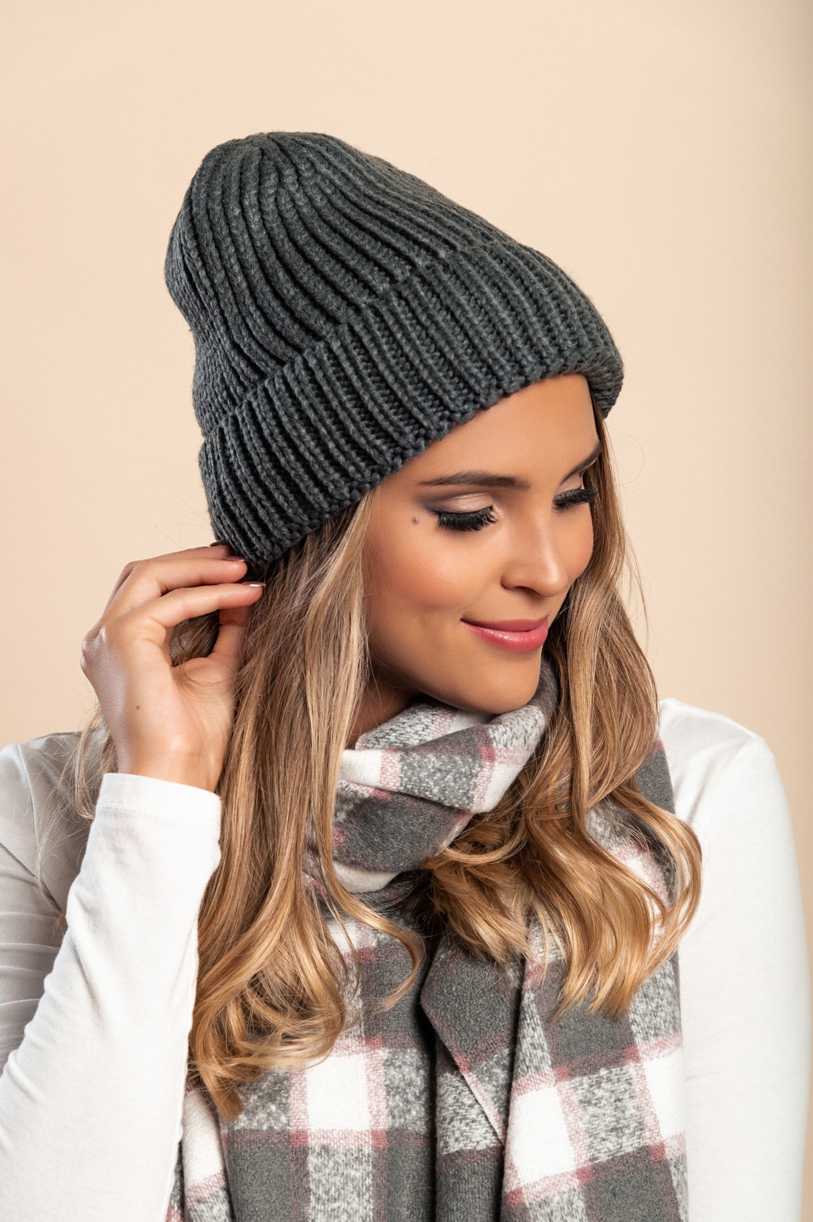 A cozy dark gray knitted hat featuring a ribbed knit design and rolled hem, perfect for winter wear.