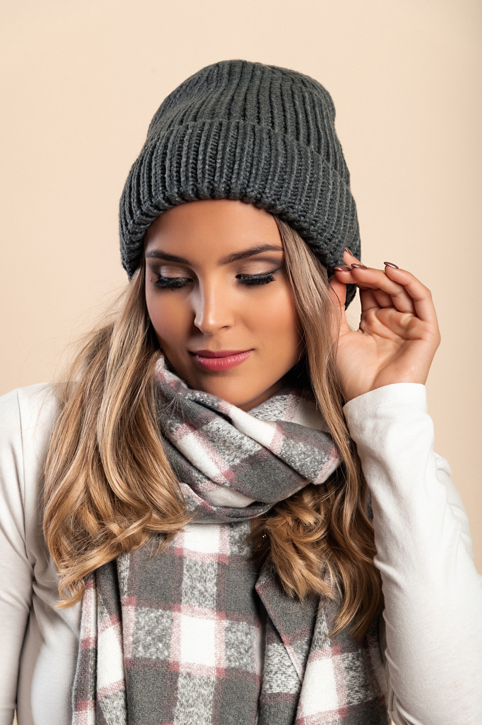 A cozy dark gray knitted hat with a ribbed design and rolled hem, perfect for winter wear.