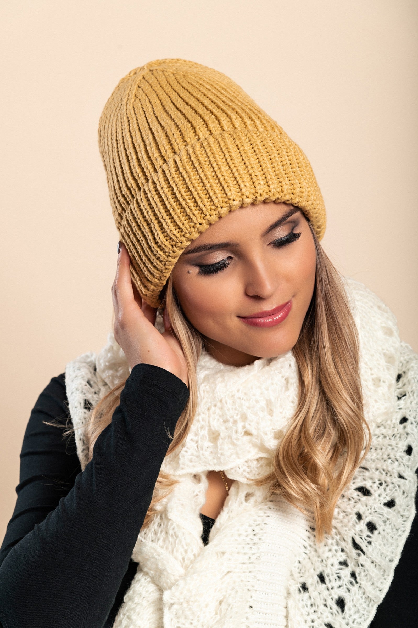 A cozy mustard knitted hat with a ribbed design and rolled hem, perfect for winter fashion.