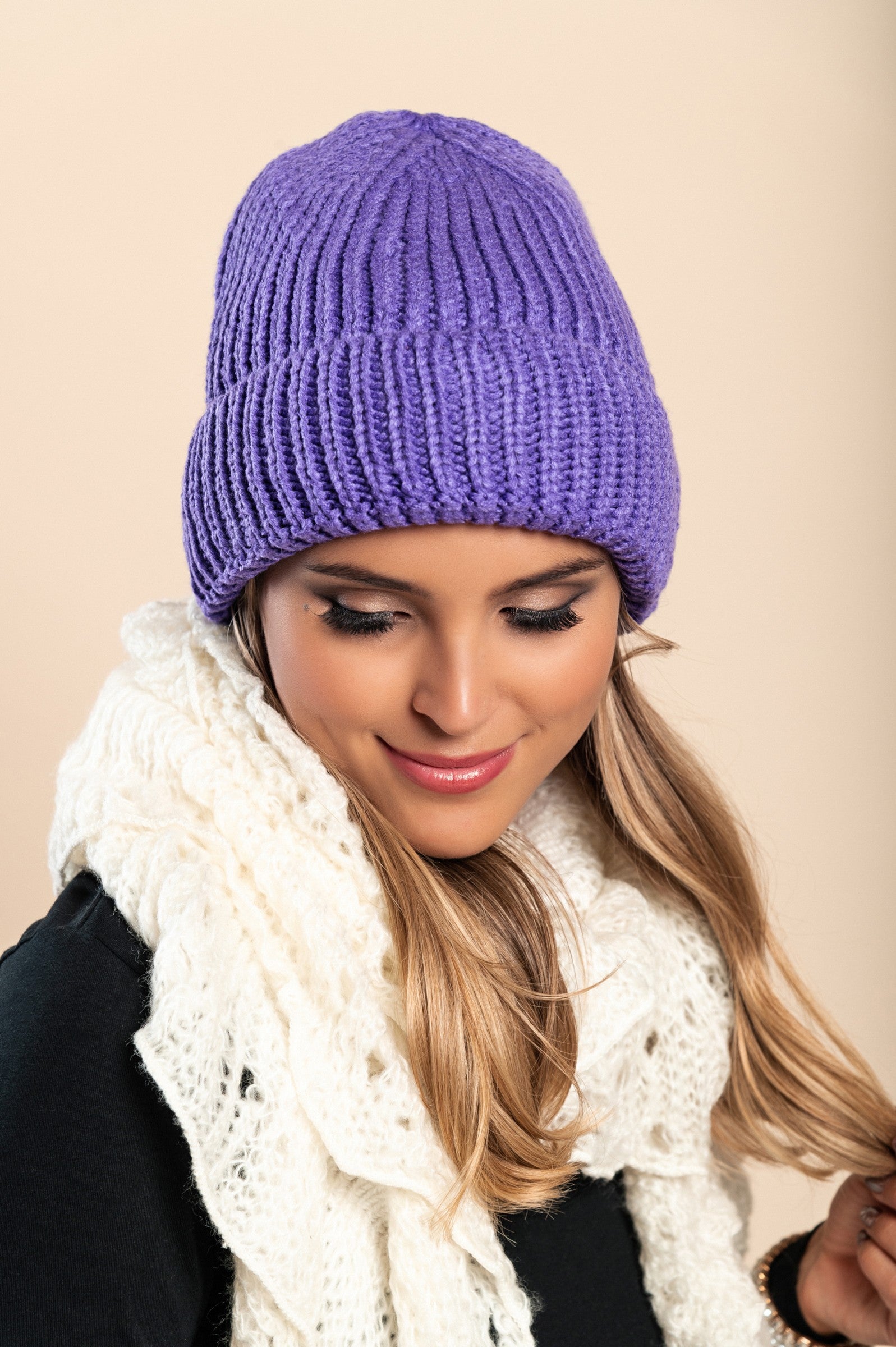 A cozy purple knitted hat made from soft fabric, featuring a ribbed knit design and rolled hem, perfect for winter wear.