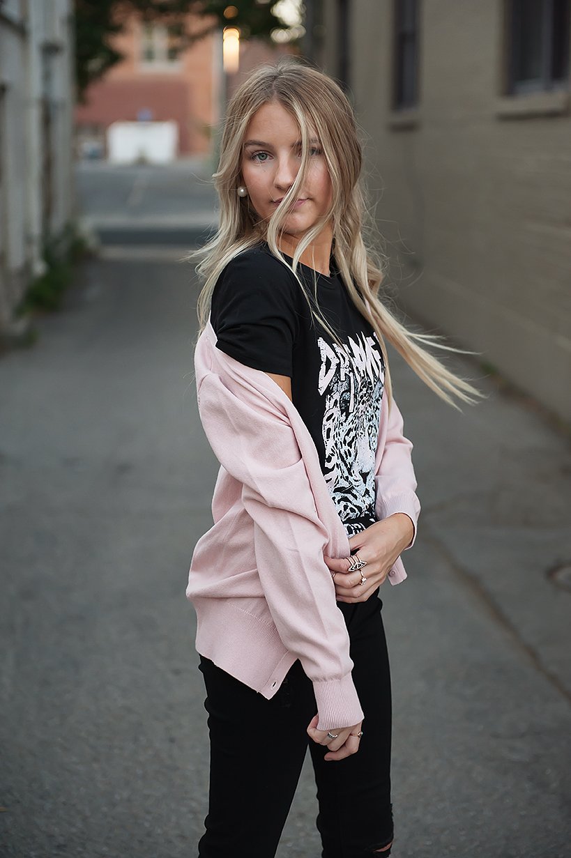 A stylish pink knitted V-neck cardigan displayed on a mannequin, showcasing its soft texture and classic design.