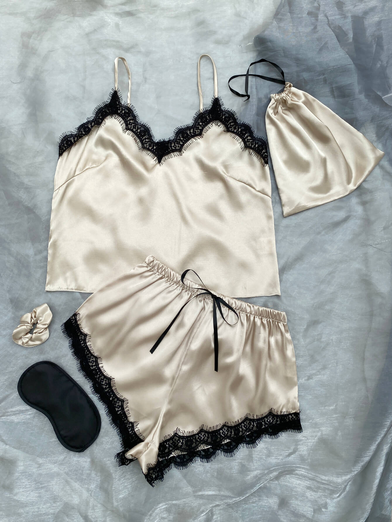 Lace Trim Cami, Shorts, Eye Mask, Scrunchie, and Bag Pajama Set displayed in a flat lay style, showcasing the elegant satin fabric and lace details.