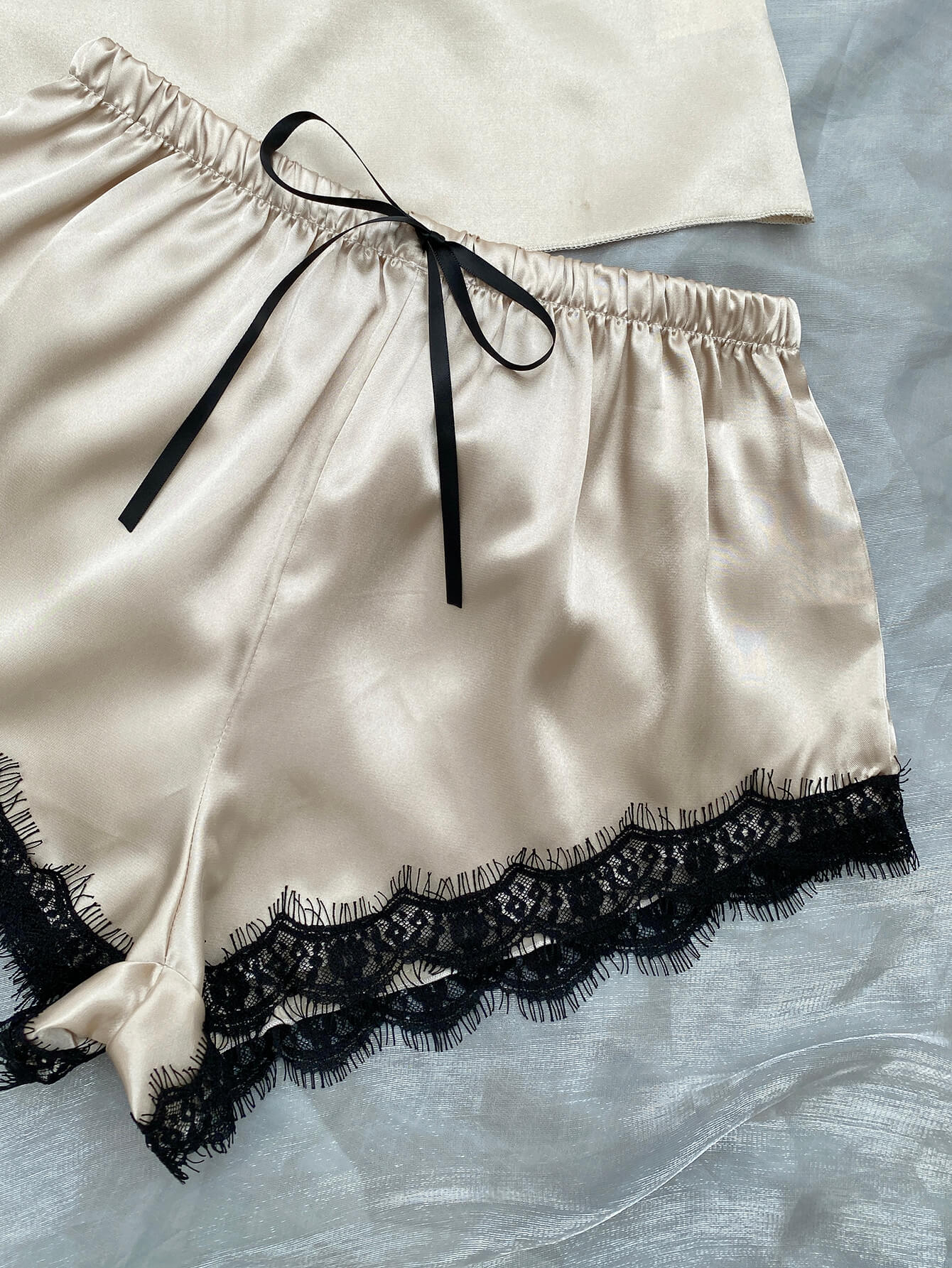 Lace Trim Cami, Shorts, Eye Mask, Scrunchie, and Bag Pajama Set displayed in a flat lay style, showcasing the elegant satin fabric and lace details.