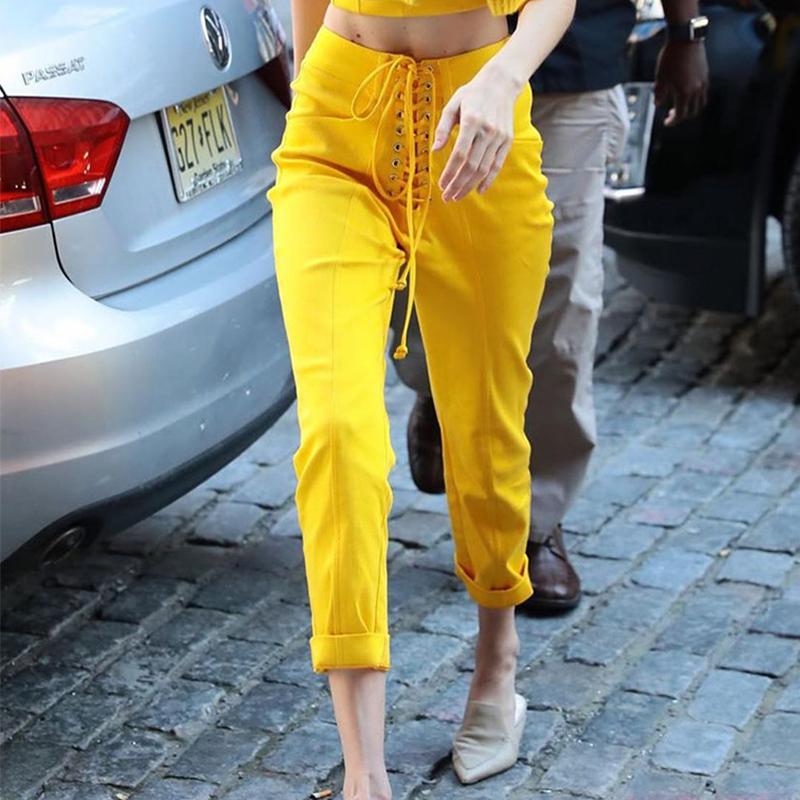 A pair of sexy yellow lace-up bodycon long pants, featuring a high waist and ankle-length design, perfect for autumn and winter fashion.