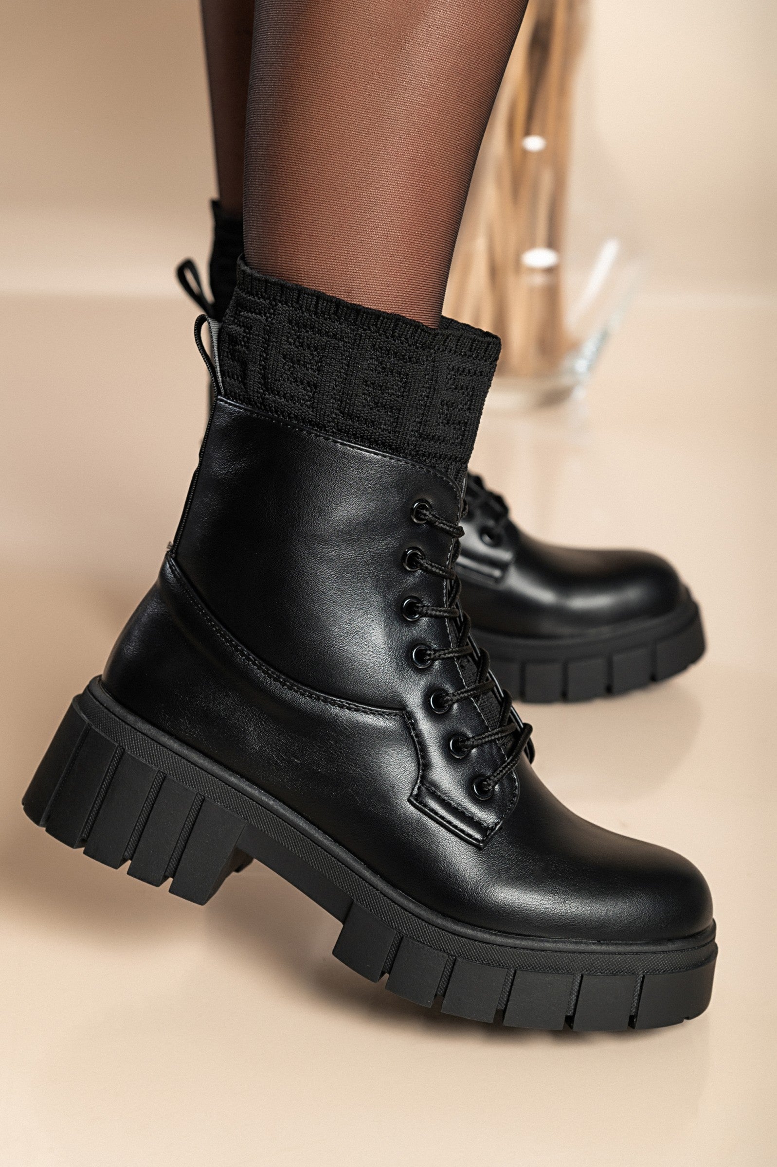 Stylish black lace-up ankle boots with round toe and raised sole, made from synthetic leather and textile.