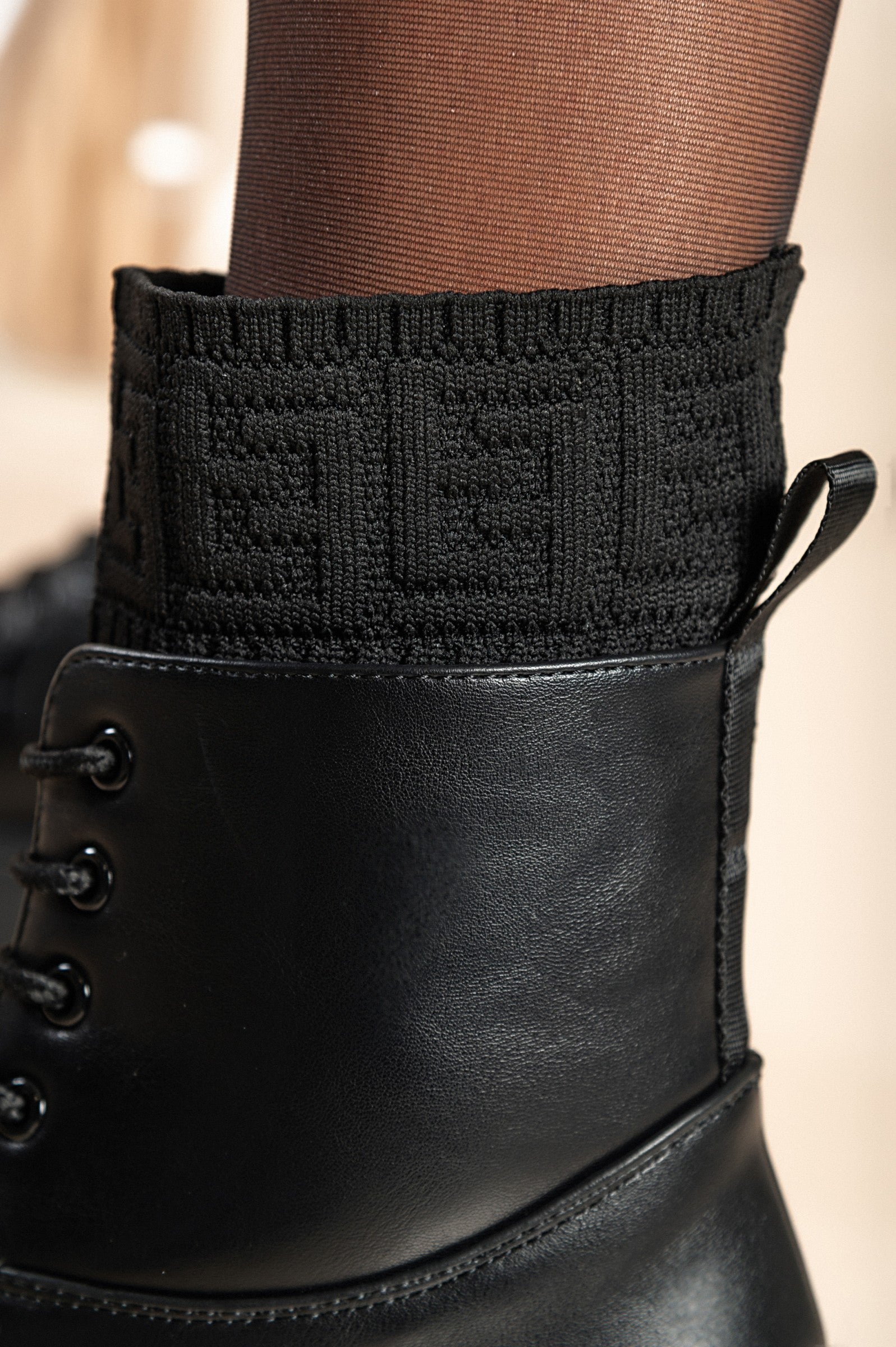 Stylish black lace-up ankle boots with round toe and raised sole, made from synthetic leather and textile.