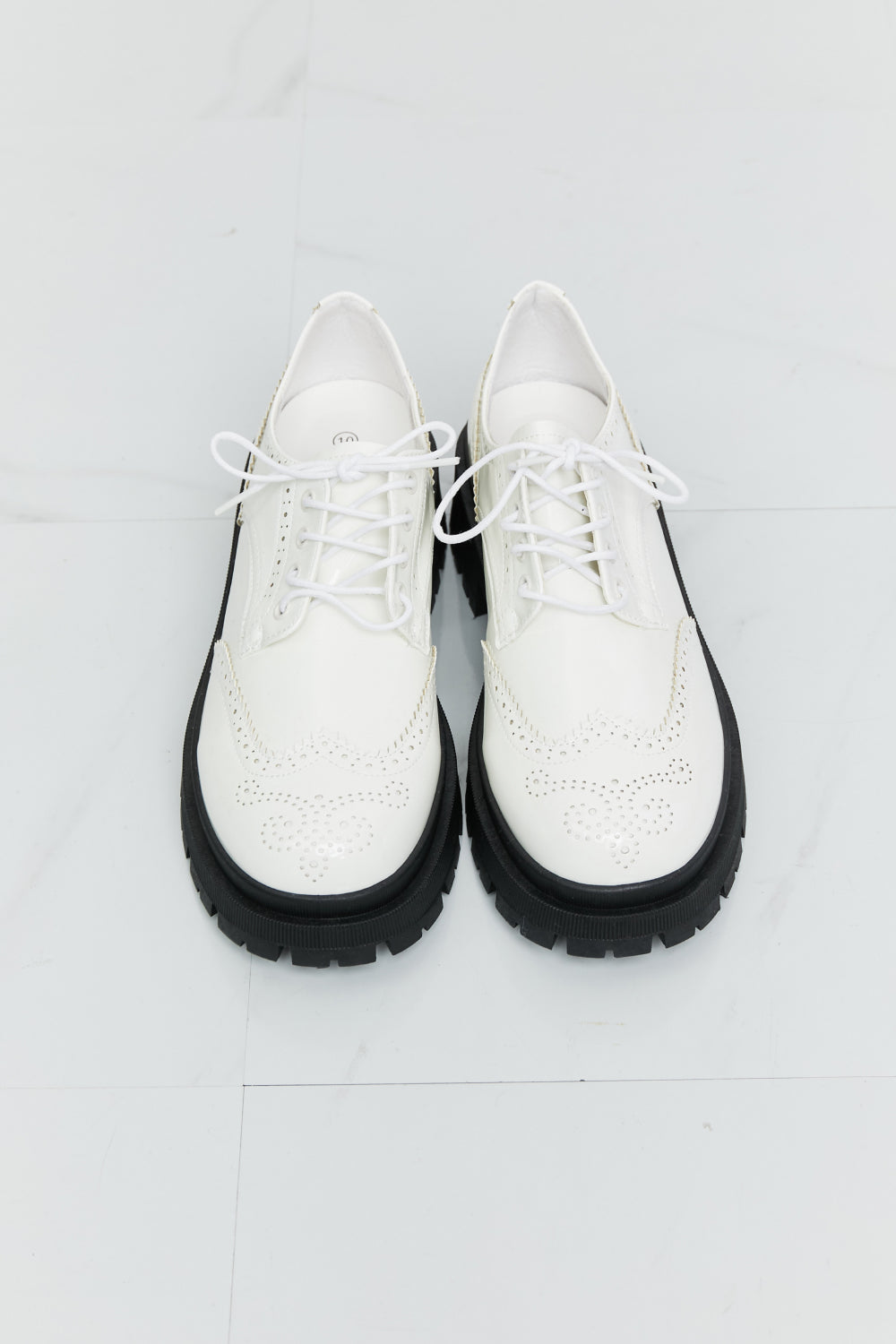 A pair of stylish Lace-Up Round Neck Shoes featuring a round toe design and low platform heels, perfect for any occasion.