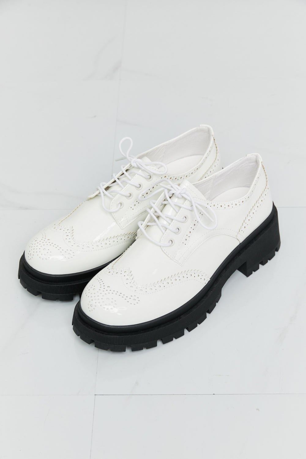 A pair of stylish Lace-Up Round Neck Shoes featuring a round toe design and low platform heels, perfect for any occasion.