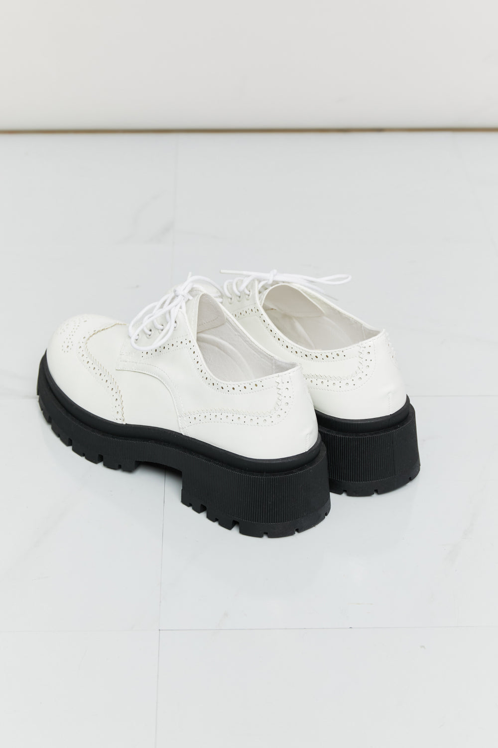 A pair of stylish Lace-Up Round Neck Shoes featuring a round toe design and low platform heels, perfect for any occasion.