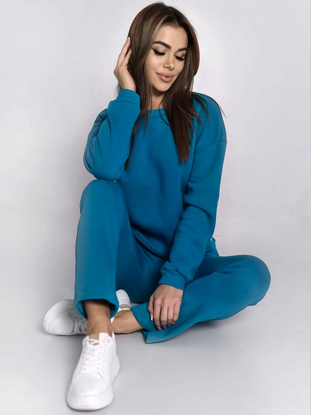 Ladies' turquoise insulated tracksuit top and loose pants set, featuring a long-sleeved sweatshirt and comfortable trousers with pockets.