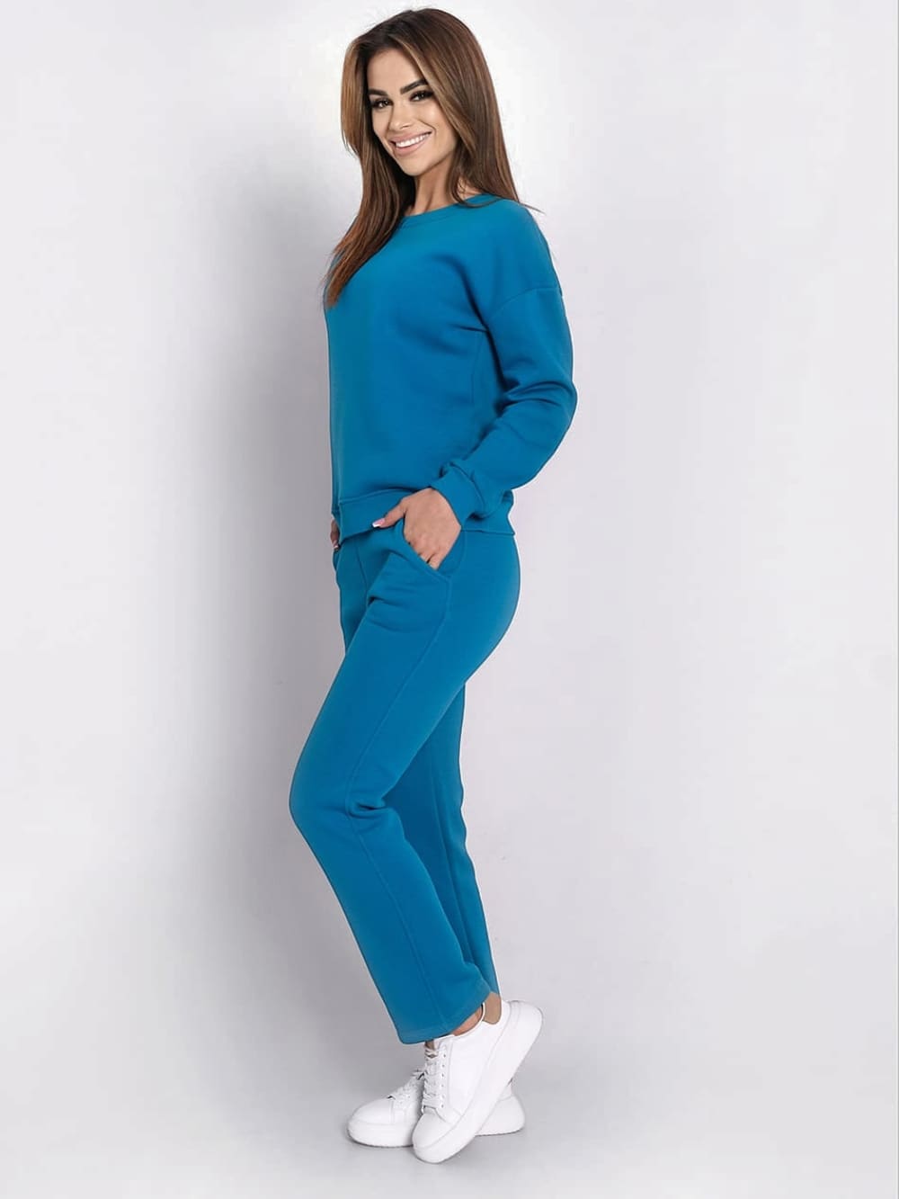 Ladies' turquoise insulated tracksuit top and loose pants set, featuring a long-sleeved sweatshirt and comfortable trousers with pockets.