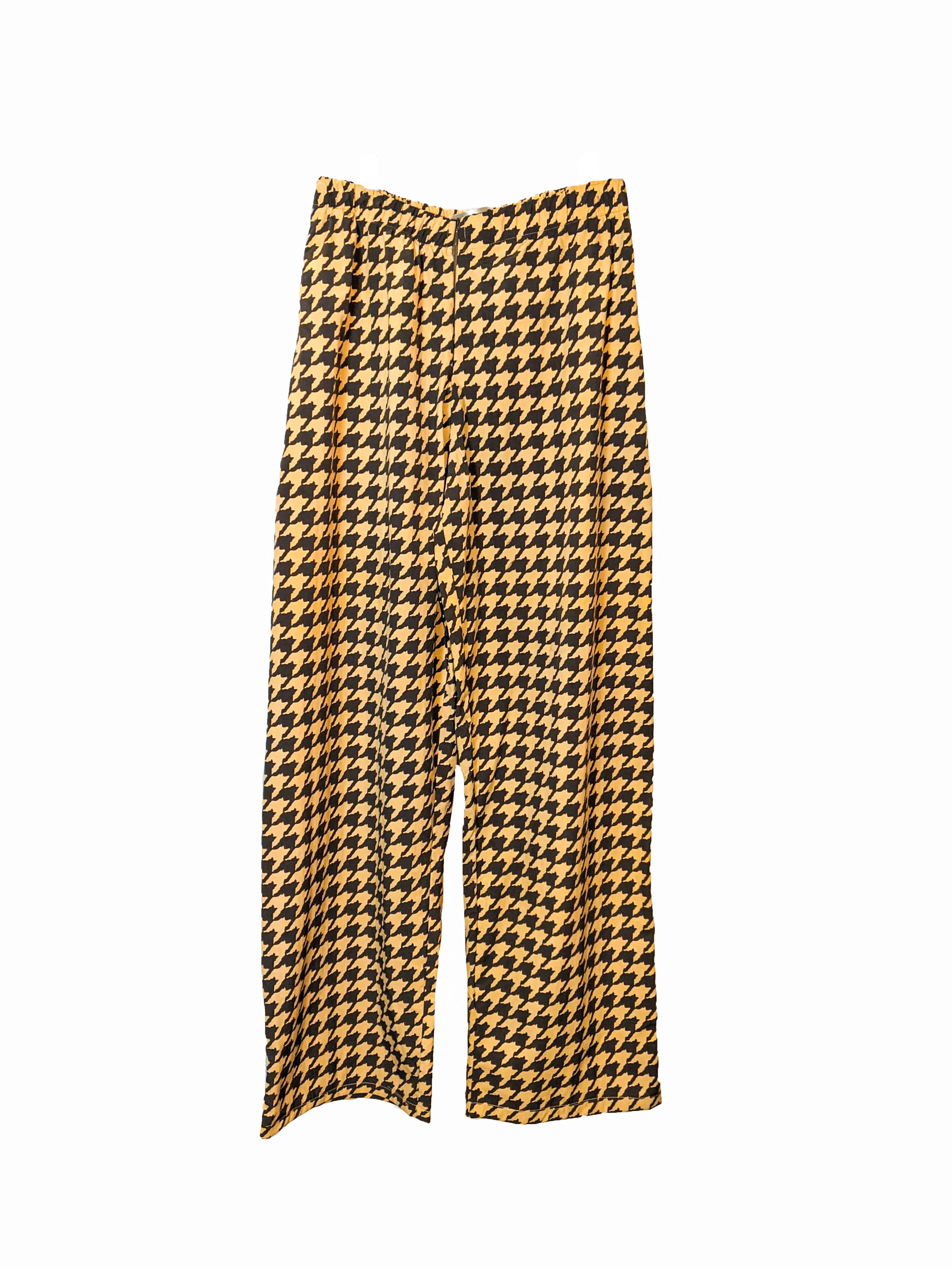 LAGINA jacket and pants suit featuring houndstooth pattern in yellow and tile brown, adorned with colorful feathers and shiny golden waistband.