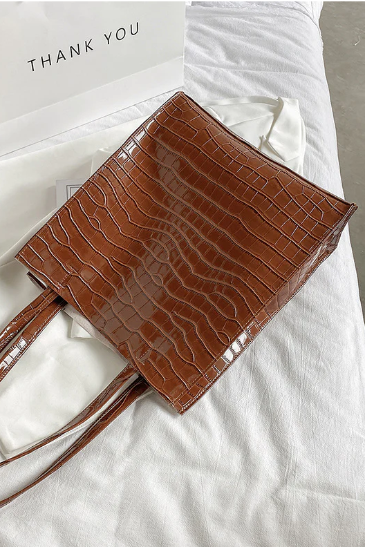 Large brown clutch bag with crocodile skin print, made of high-quality faux leather, stylish and spacious design.