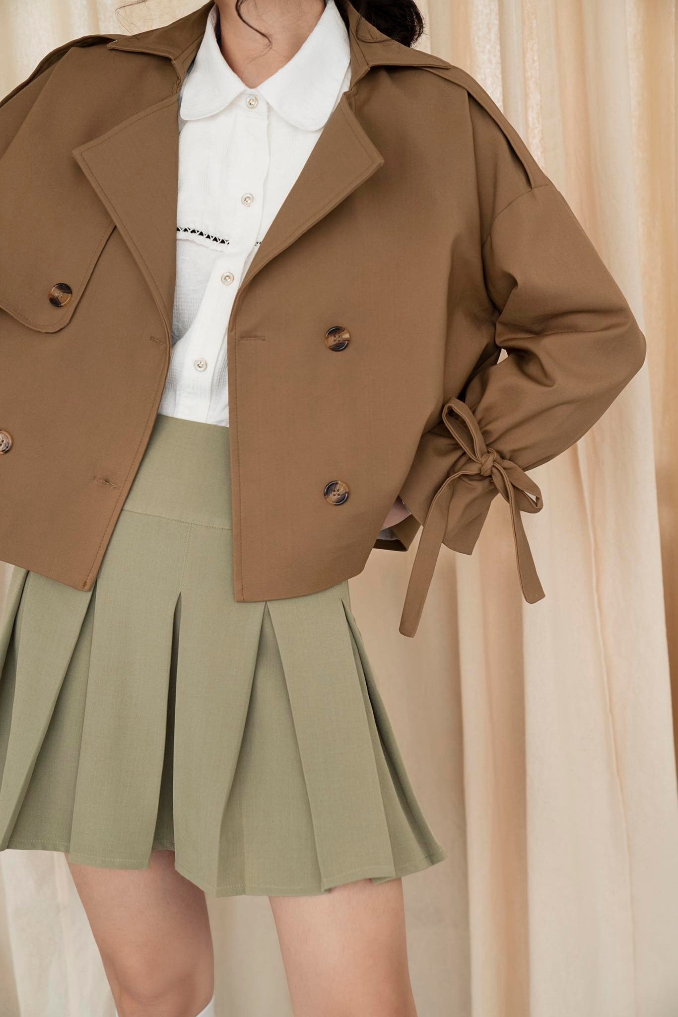 Layla Cropped Trenchcoat in khaki leather, showcasing its stylish cropped design and smooth surface.